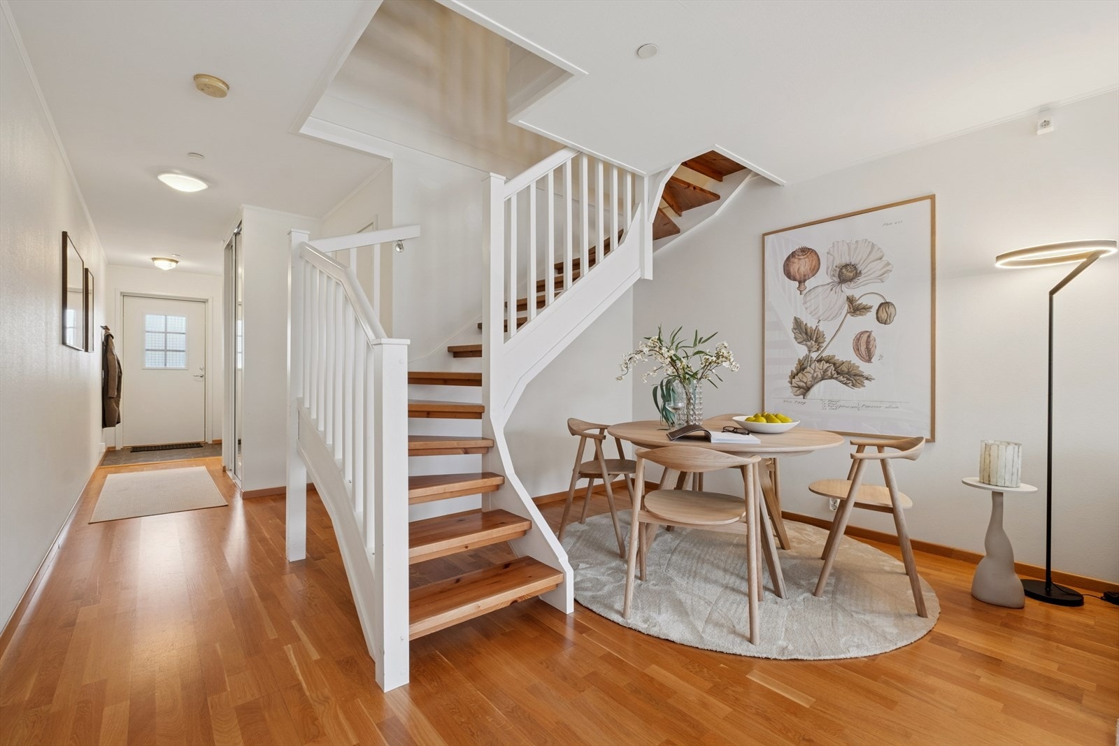 Det er plass til spisestuemøblement ved siden av den pene trappen som fører opp til soverommene. Galleribilde