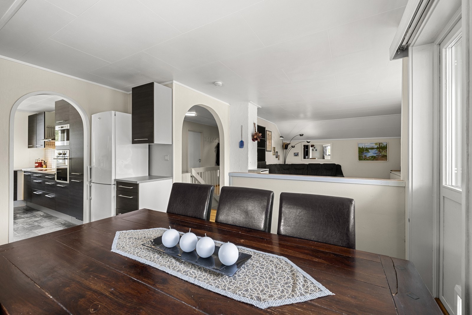 Utsyn fra spiseplassen mot stuen og kjøkkenet understreker den åpne planløsningen. Galleribilde