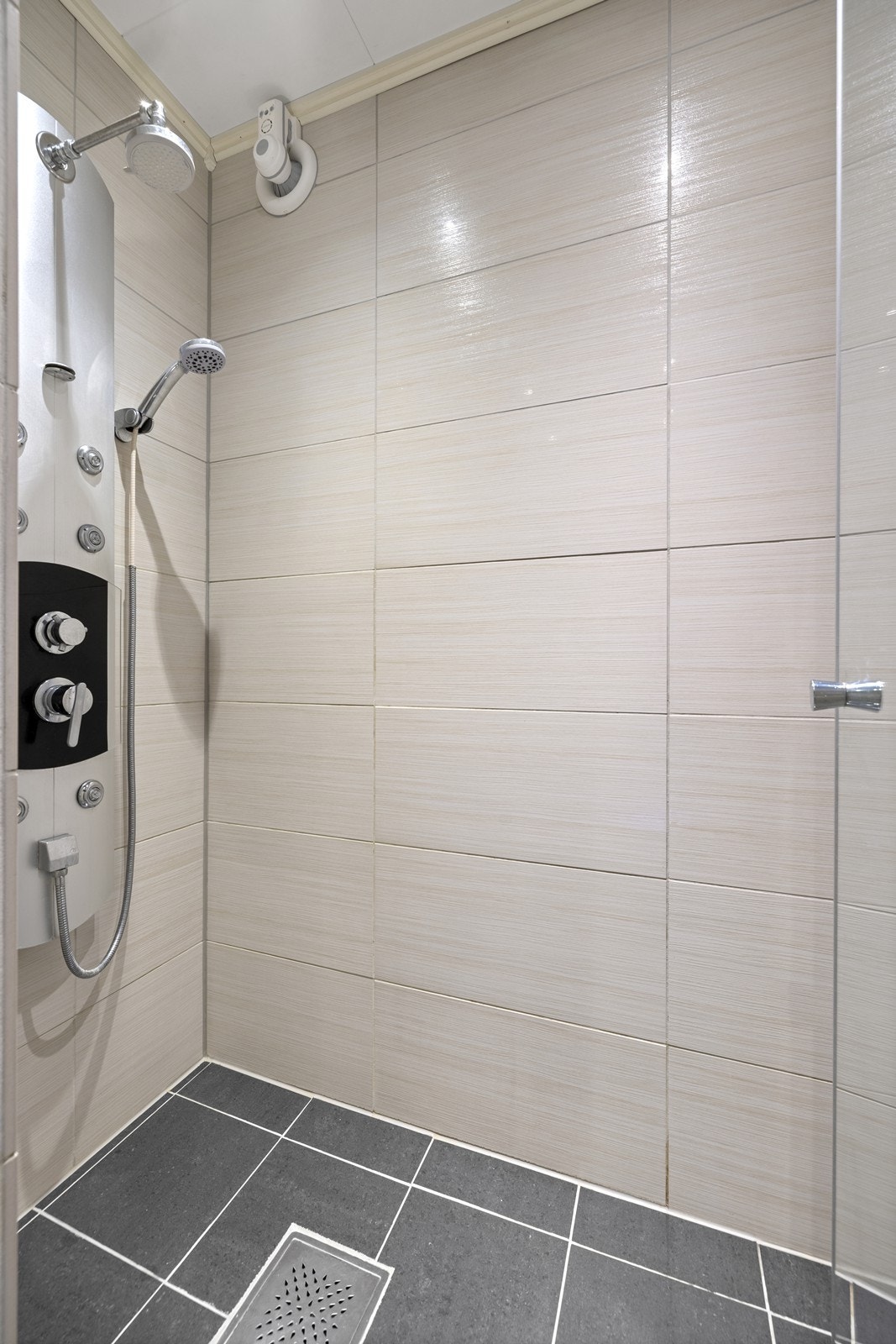 Rommet har en praktisk dusjsone, vegghengt toalett og servant med underskap. Galleribilde