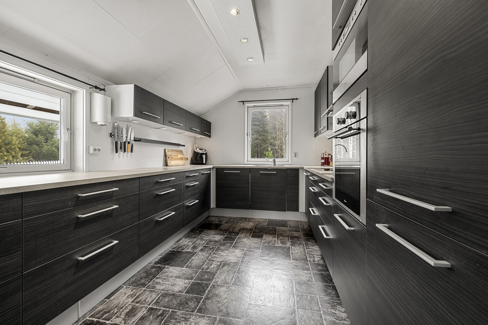 Moderne kjøkken fra 2011 med en stilren innredning og rikelig med skap- og benkeplass. Galleribilde