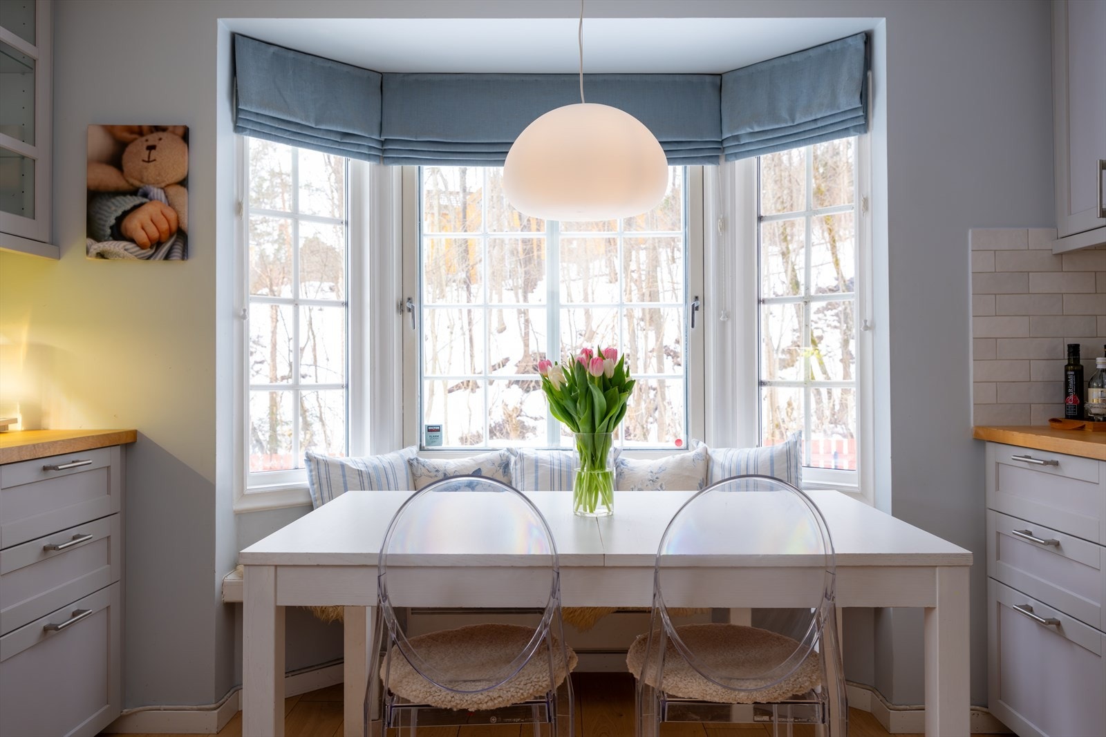 Koselig spiseplass i karnapp med sittebenk og store vindusflater som slipper inn godt med naturlig lys Galleribilde