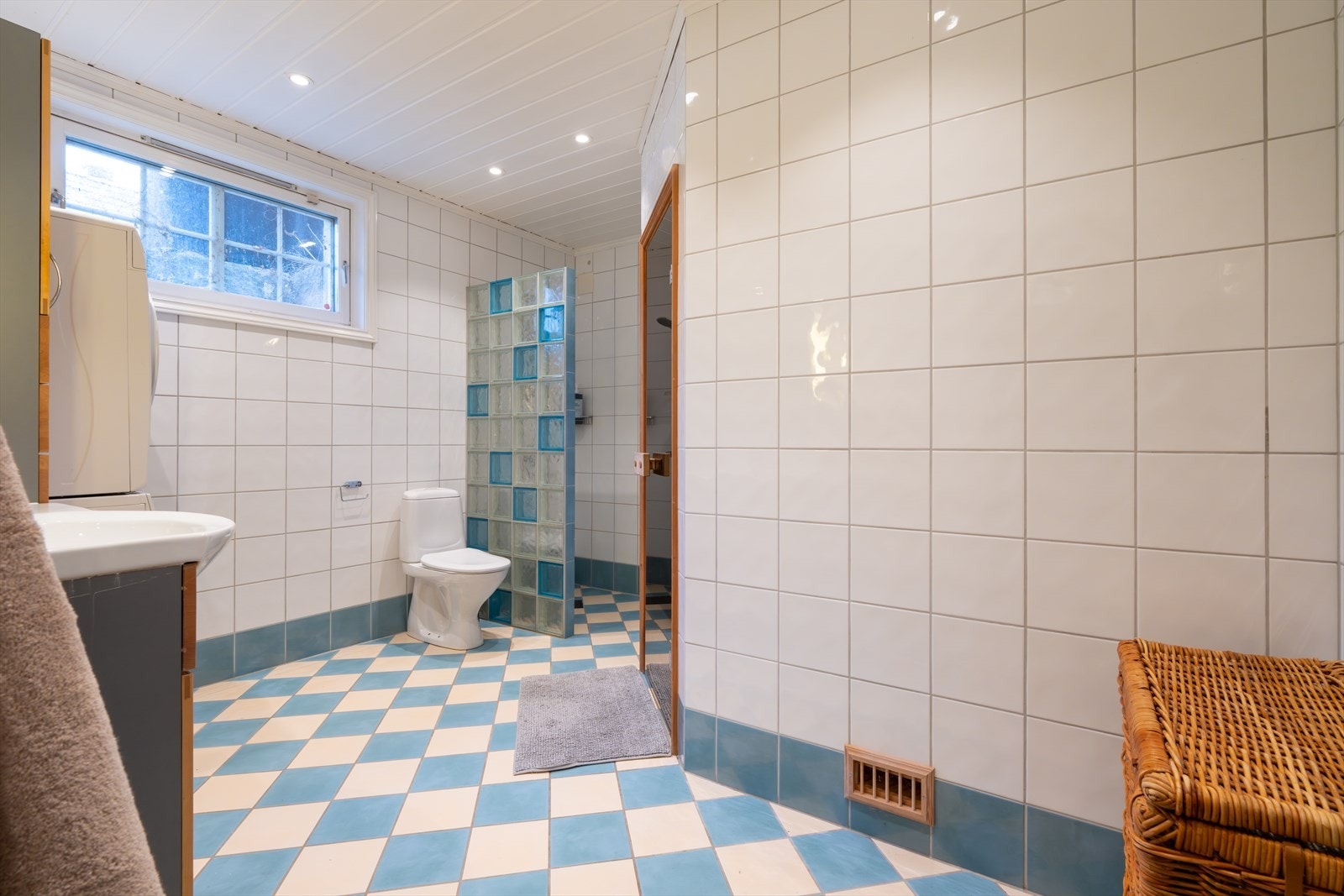 Badet har flislagte overflater og dusjnisje med glassbyggerstein Galleribilde