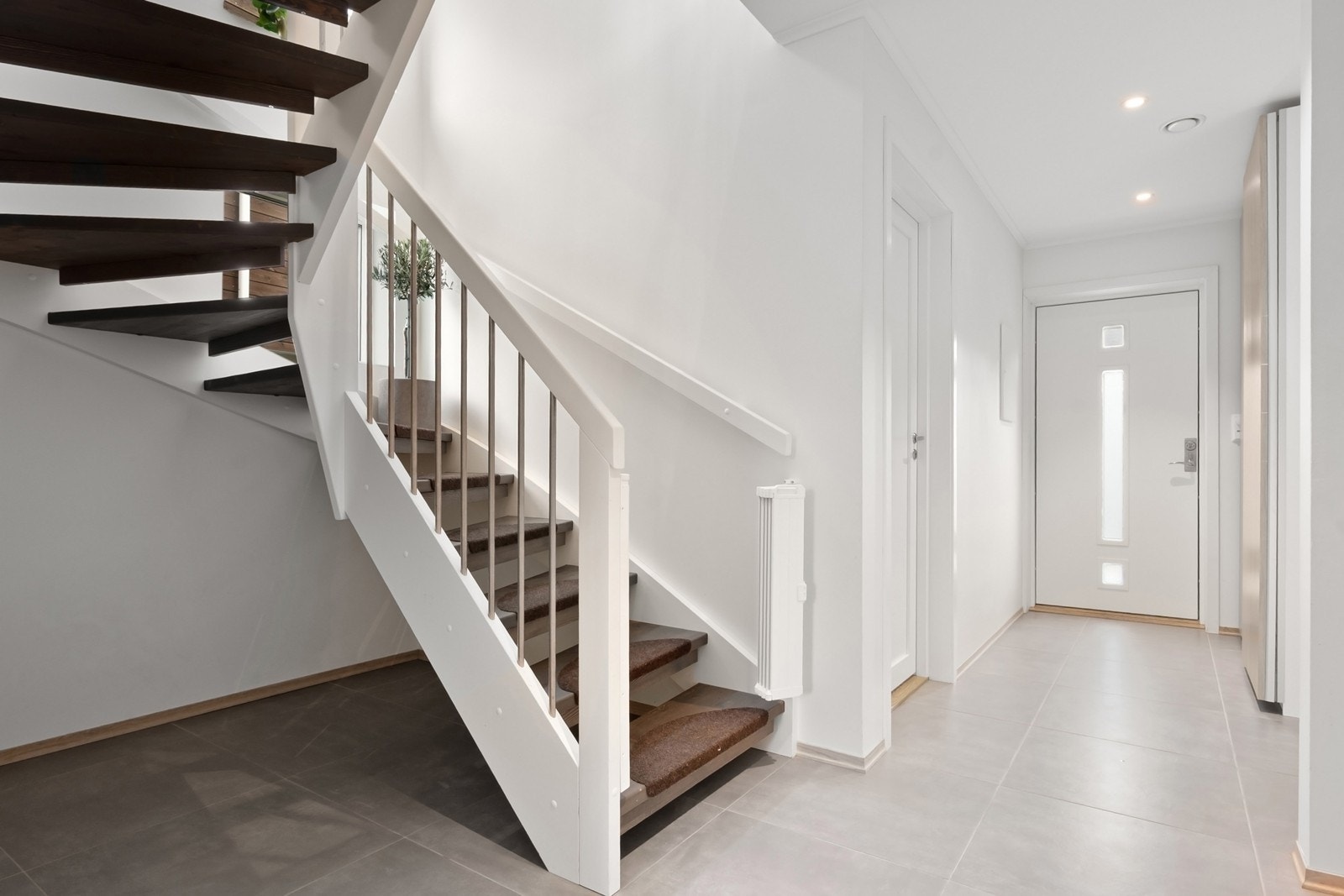 Fra gangen er det adkomst til boligens bad, vaskerom og tre av boligens fire soverom, samt trapp opp til en lys og luftig andre etasje. Galleribilde