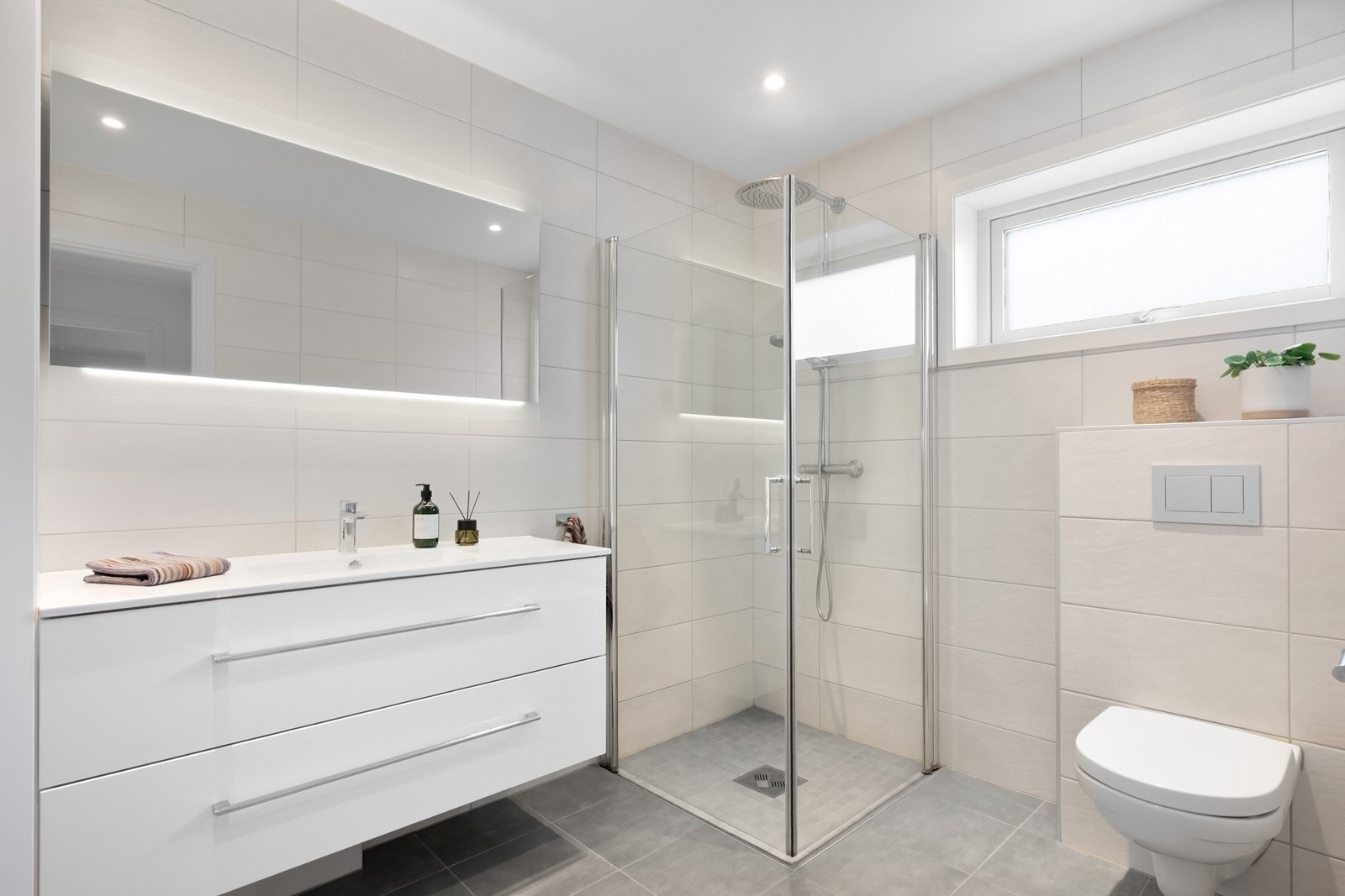 Baderommet er delikat med flislagte overflater, lys innredning og gulv med gulvvarme. Galleribilde