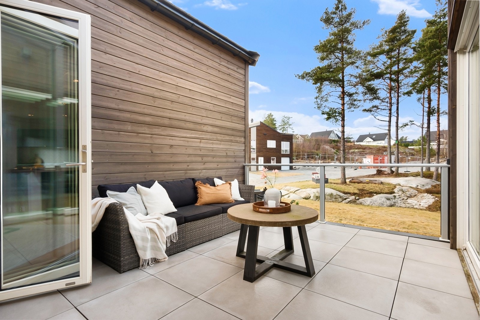 Terrassen på 12 kvm har glassrekkverk og store gulvfliser. Galleribilde