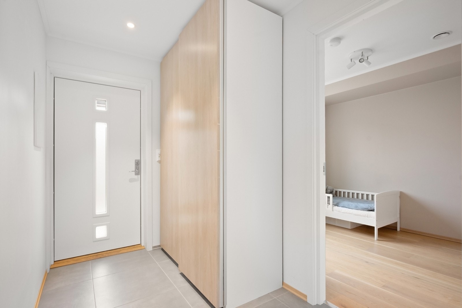 Entreen har flislagt gulv med behagelig gulvvarme. Et romslig garderobeskap gir gode oppbevaringsmuligheter for yttertøy og sko. Galleribilde