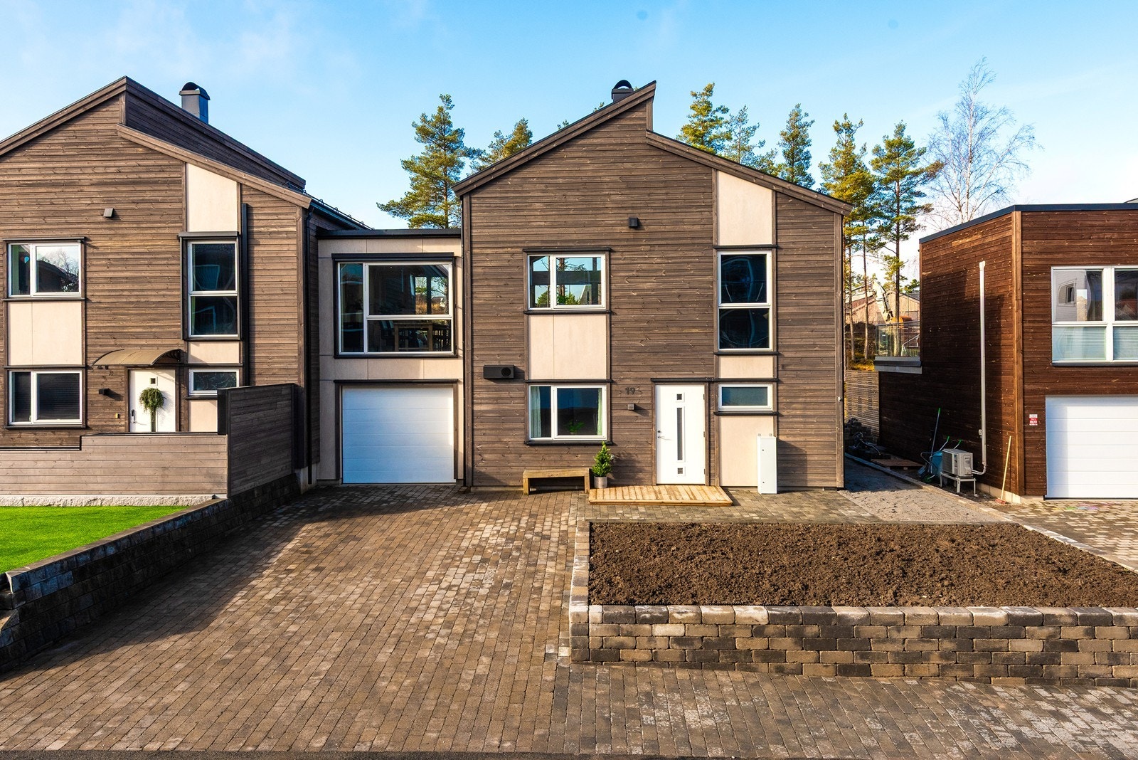 Det er parkering i både garasje med elbillader og på steinlagt gårdsplass. Galleribilde