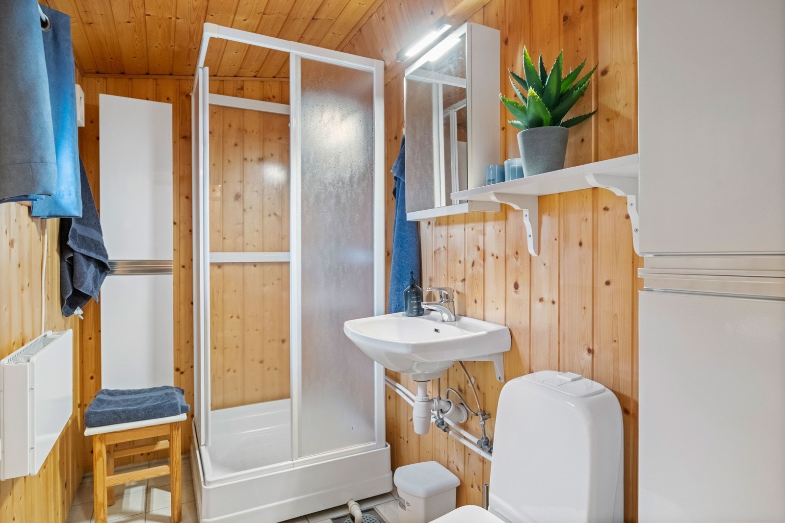 Badet i 1. etasje er fra ca. 2003 og har flislagt gulv med gulvvarme, panelte vegger og panelte innvendige tak Galleribilde