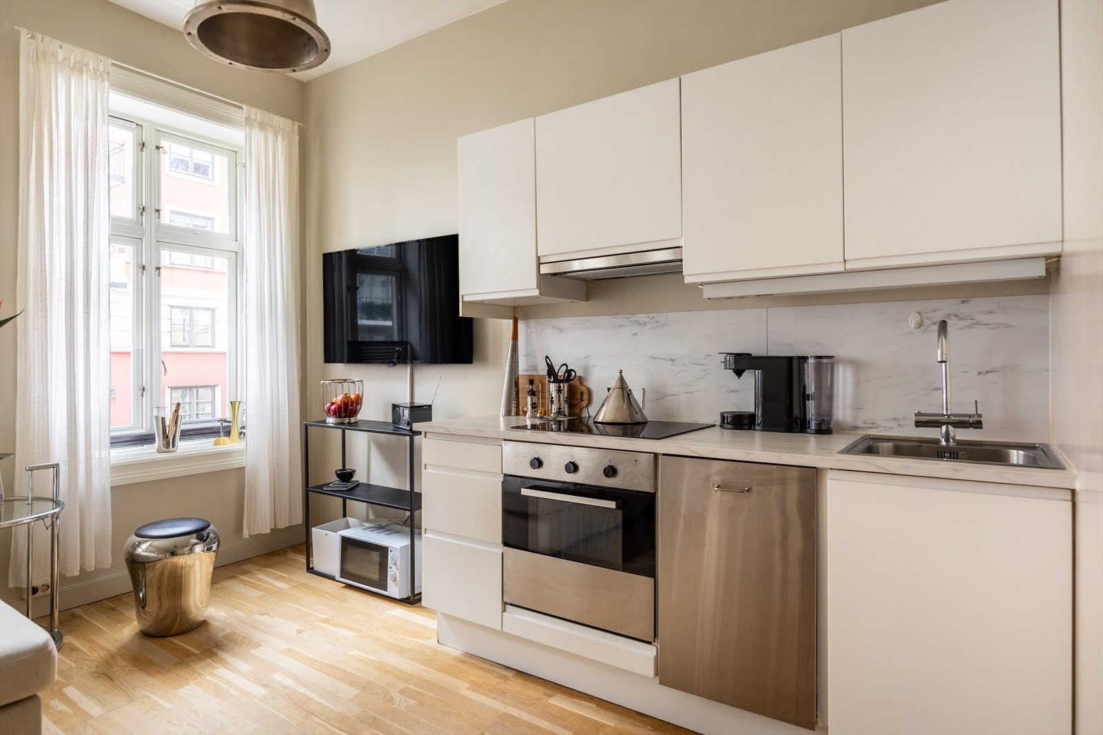 IKEA kjøkkeninnredning med integrerte hvitevarer: oppvaskmaskin, stekeovn og kombinert kjøl/frys. Galleribilde