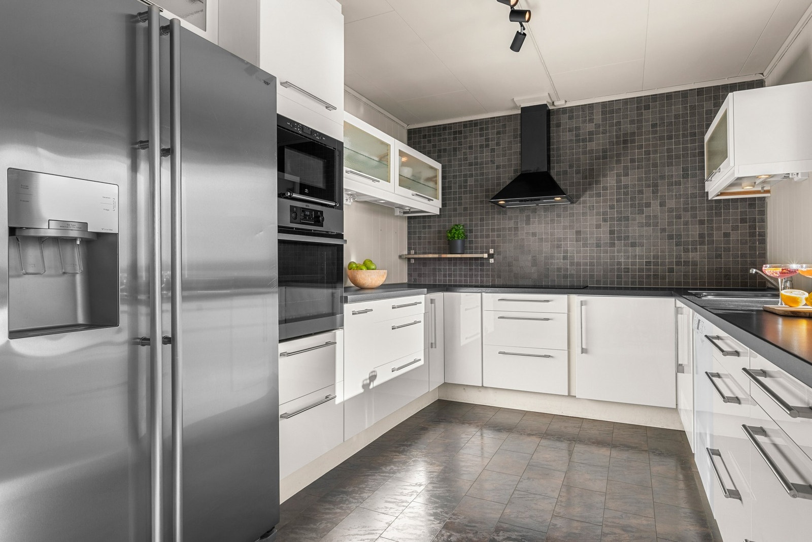 Moderne og stilrent kjøkken med integrerte hvitevarer og godt med benkeplass. Galleribilde