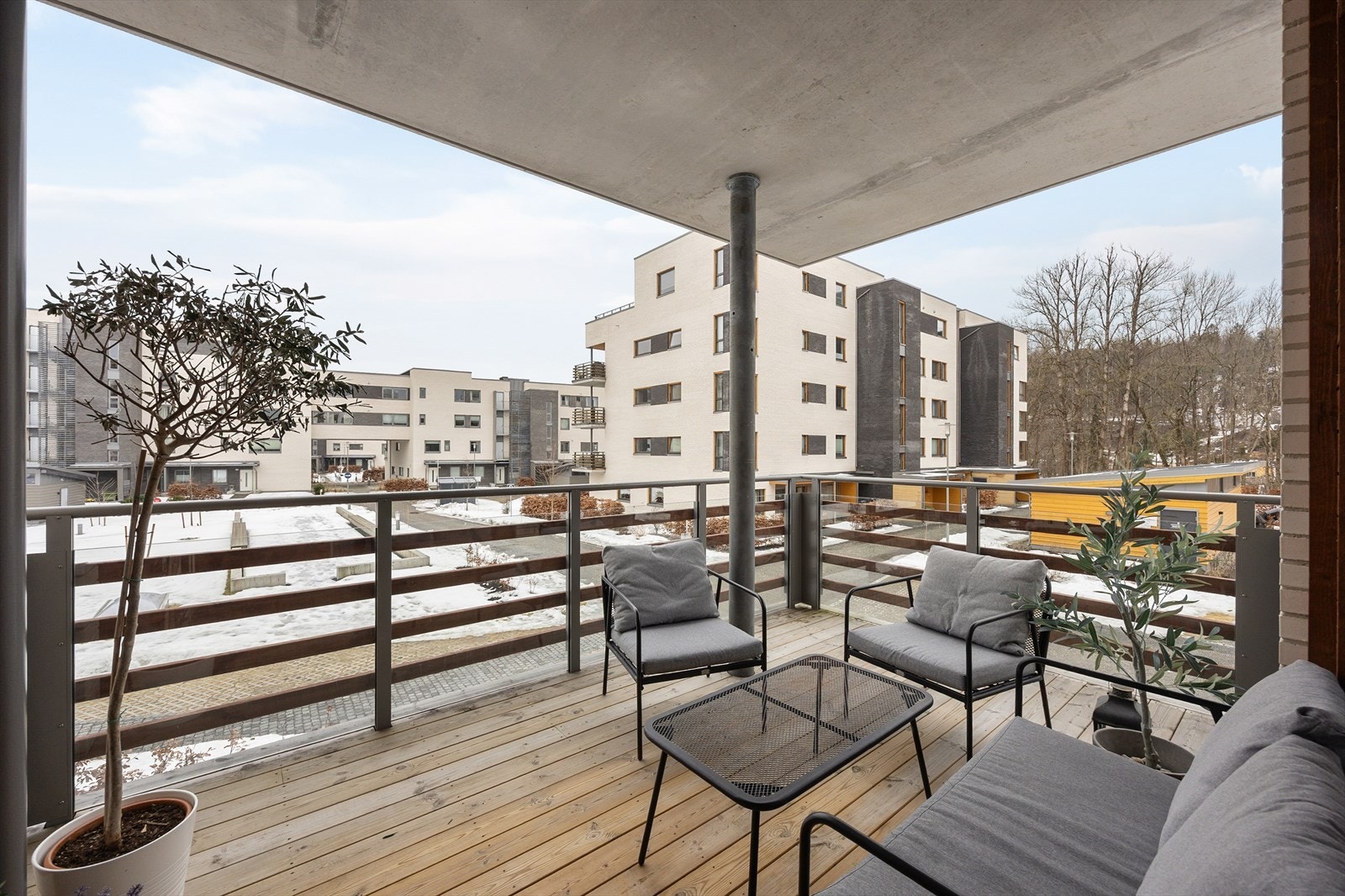 Balkongen har gulv av tre og rekkverk i stål og glass. Galleribilde