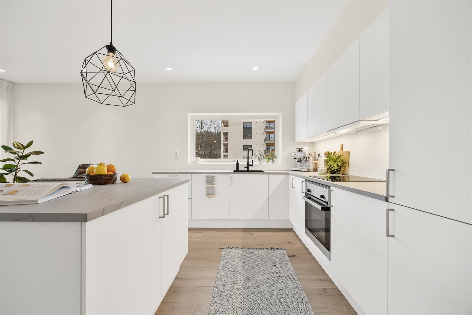 Leiligheten fra 2023 har en åpen og sosial planløsning mellom stue og kjøkken. Galleribilde