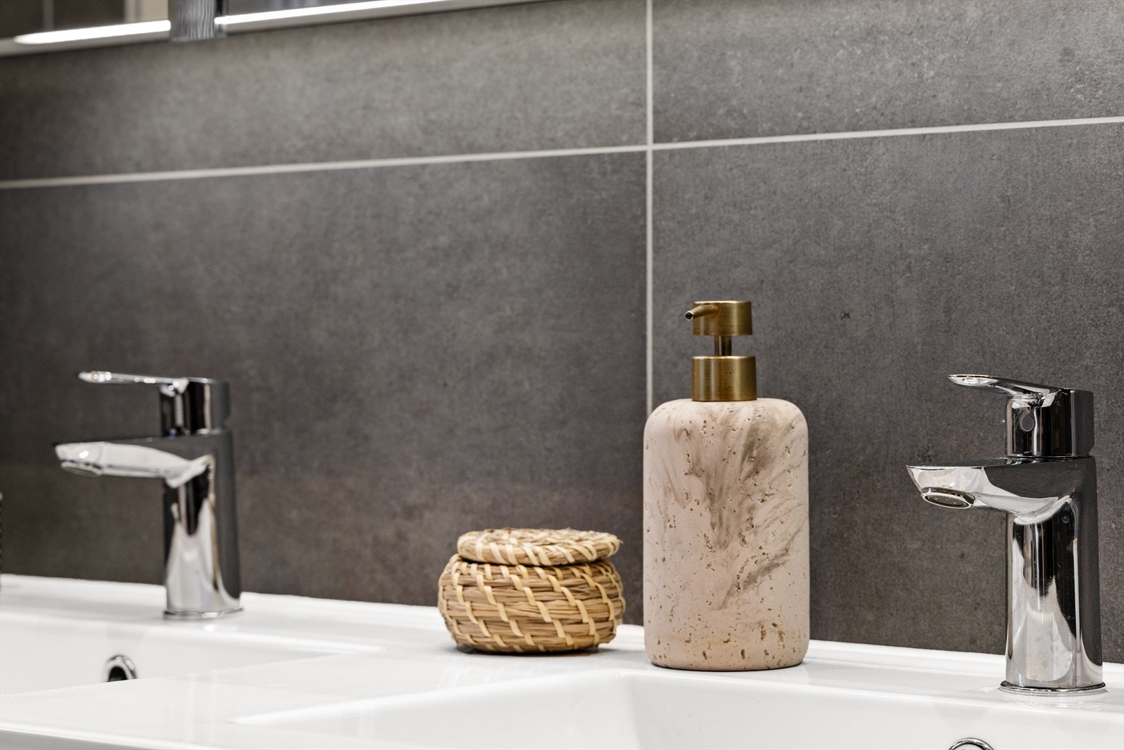 Innredningen inkluderer doble porselenservanter og et romslig speilskap med belysning. Galleribilde