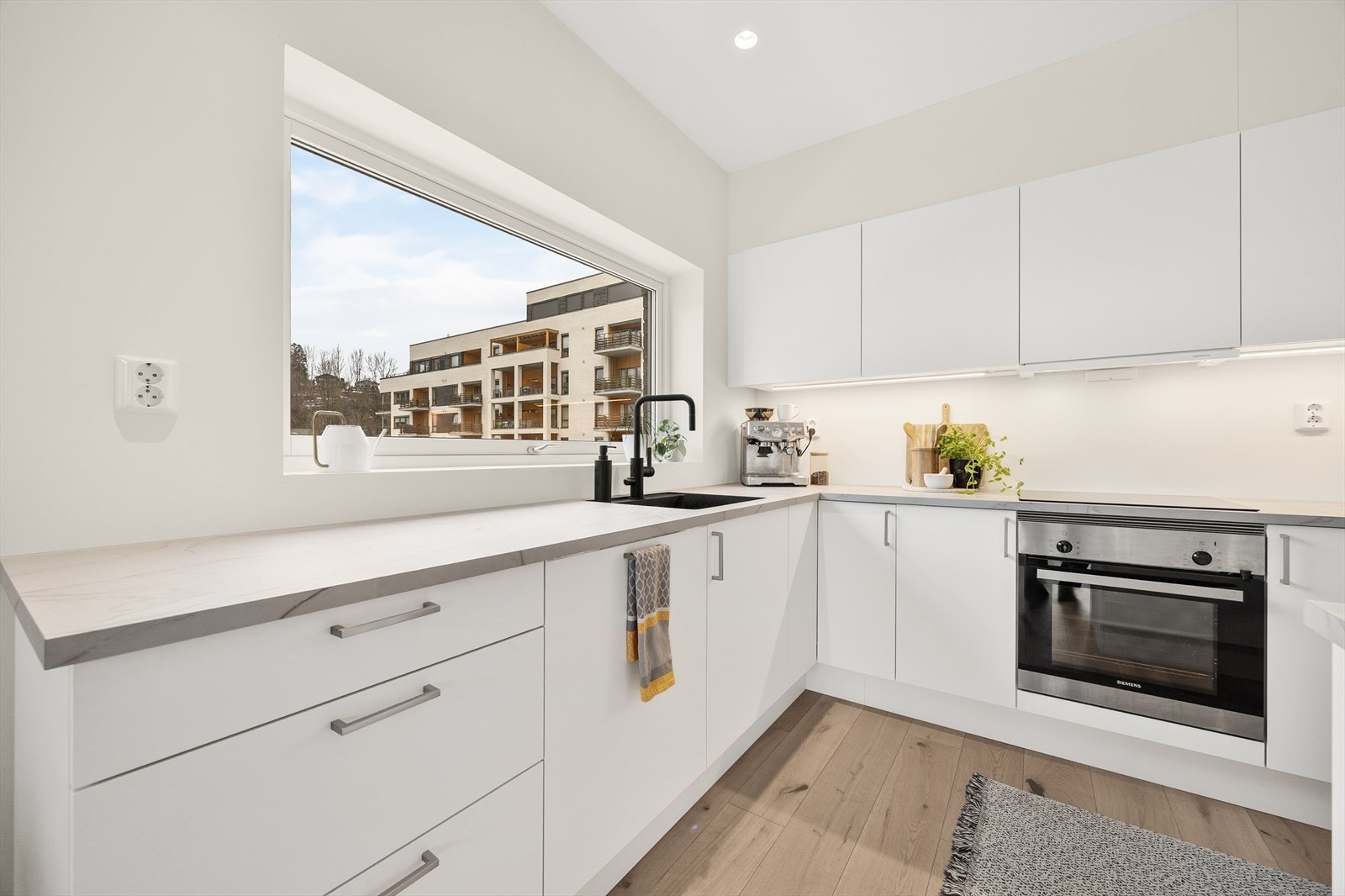 Kjøkkenet har en moderne innredning med slette fronter og slitesterk laminat benkeplate. Galleribilde