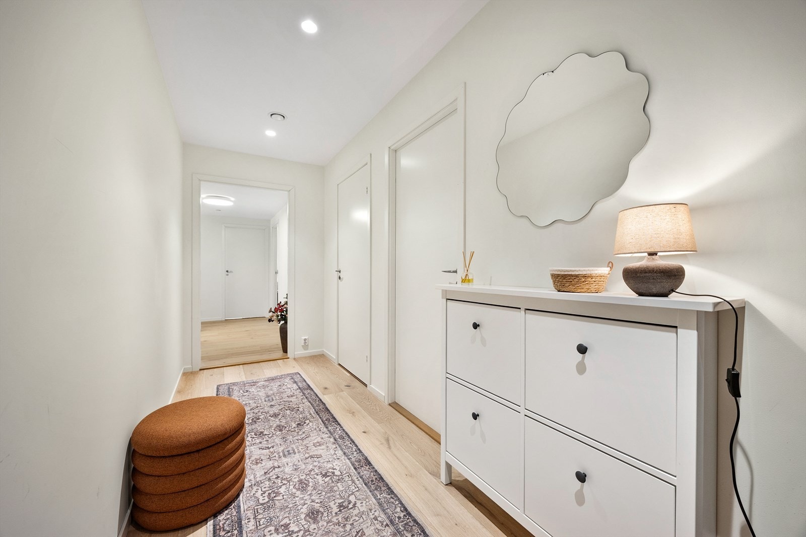 En romslig entré med direkte inngang til et soverom og det ene badet. Galleribilde