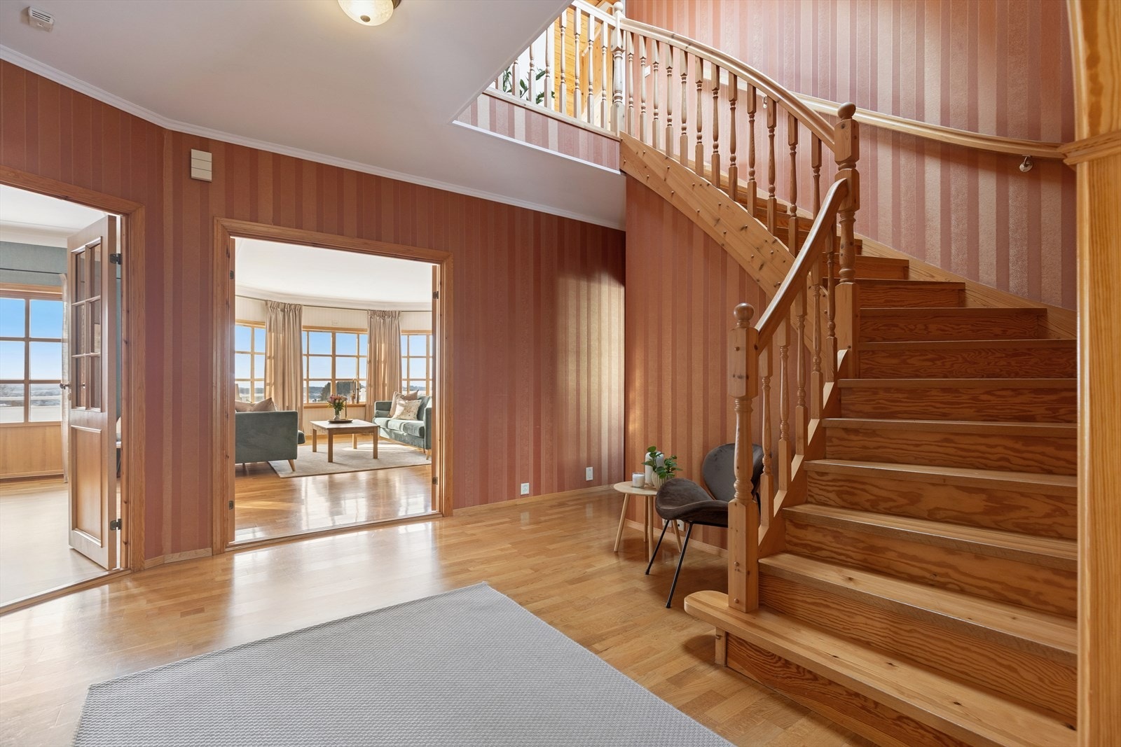 Romslig hall med trapp opp til loftsetasjen. Galleribilde