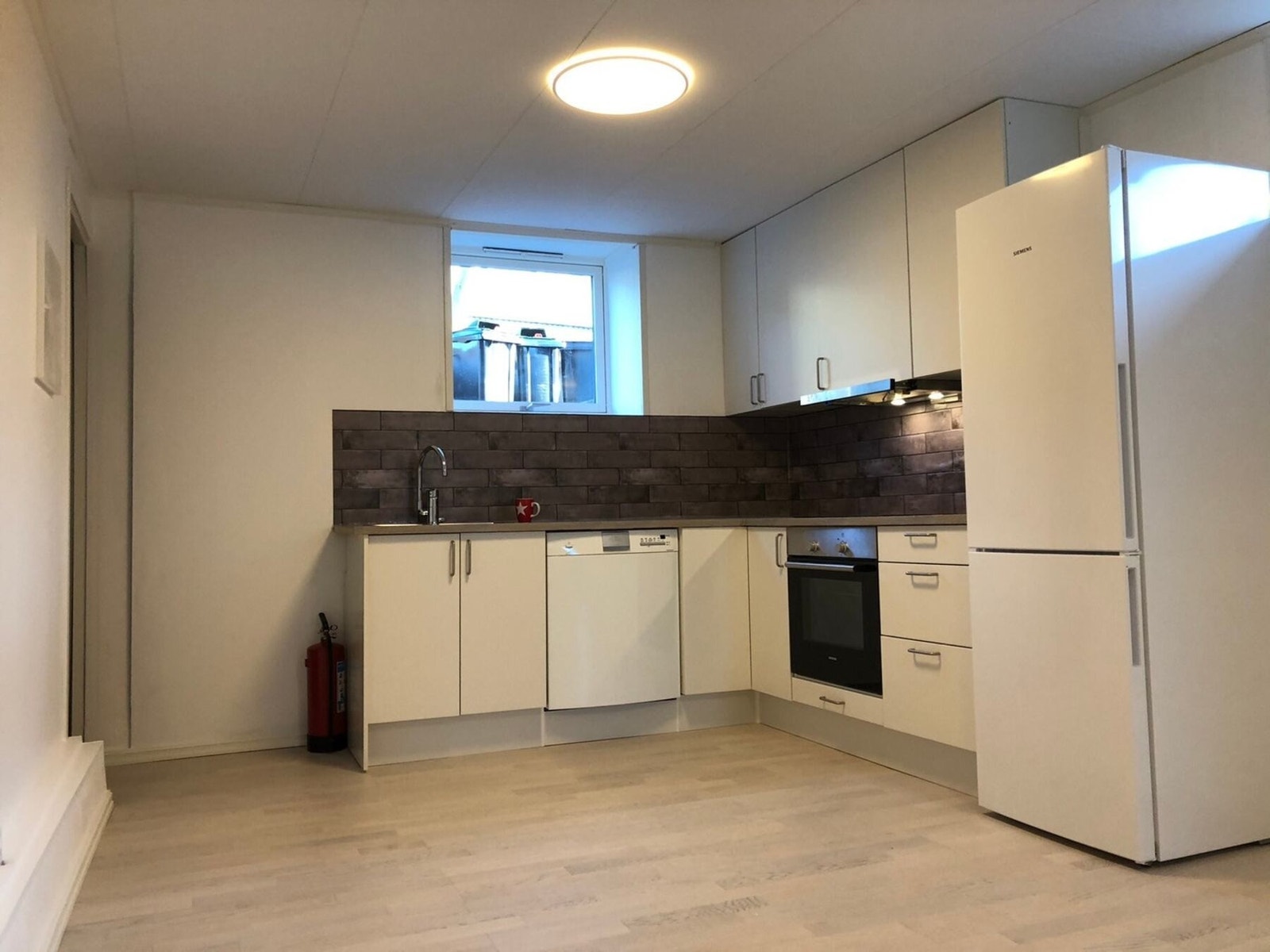 Kjøkkeninnredningen har glatte fronter, laminat benkeplate og integrerte hvitevarer som induksjonstopp og stekeovn. Automatisk vannstopper er montert. Kjelleretasjen er bruksendret og godkjent for varig opphold Galleribilde