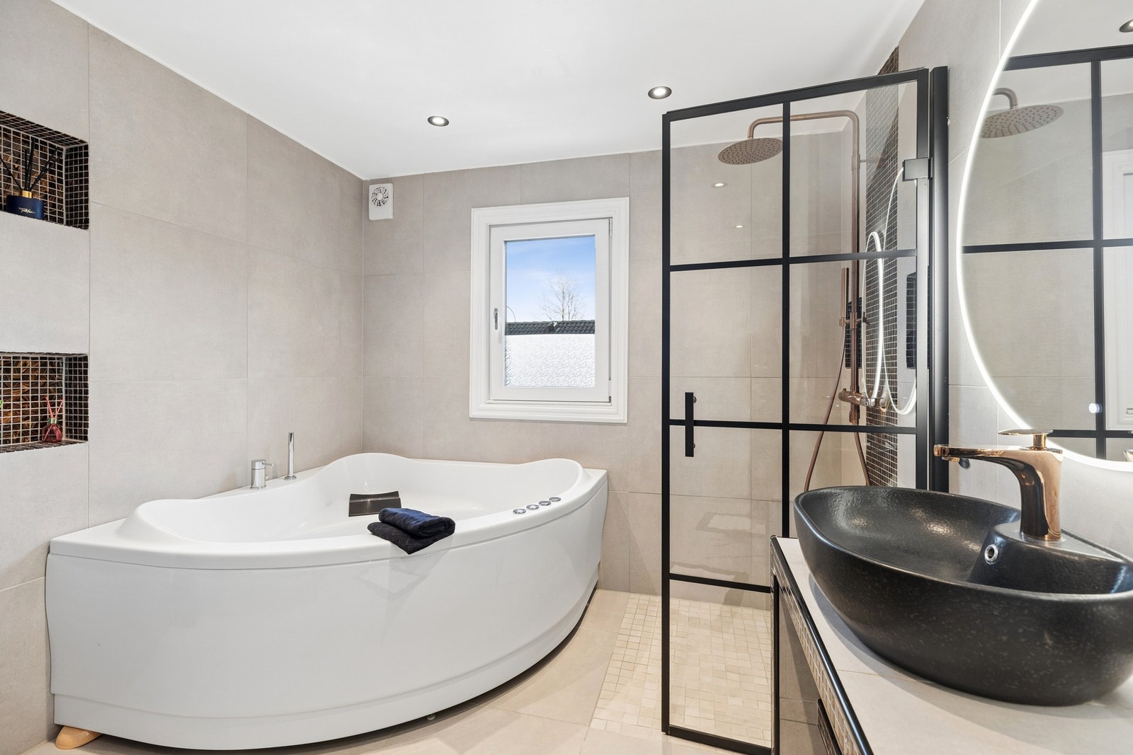 Badet har dusj med innfellbare glassdører og boblebadekar. Galleribilde