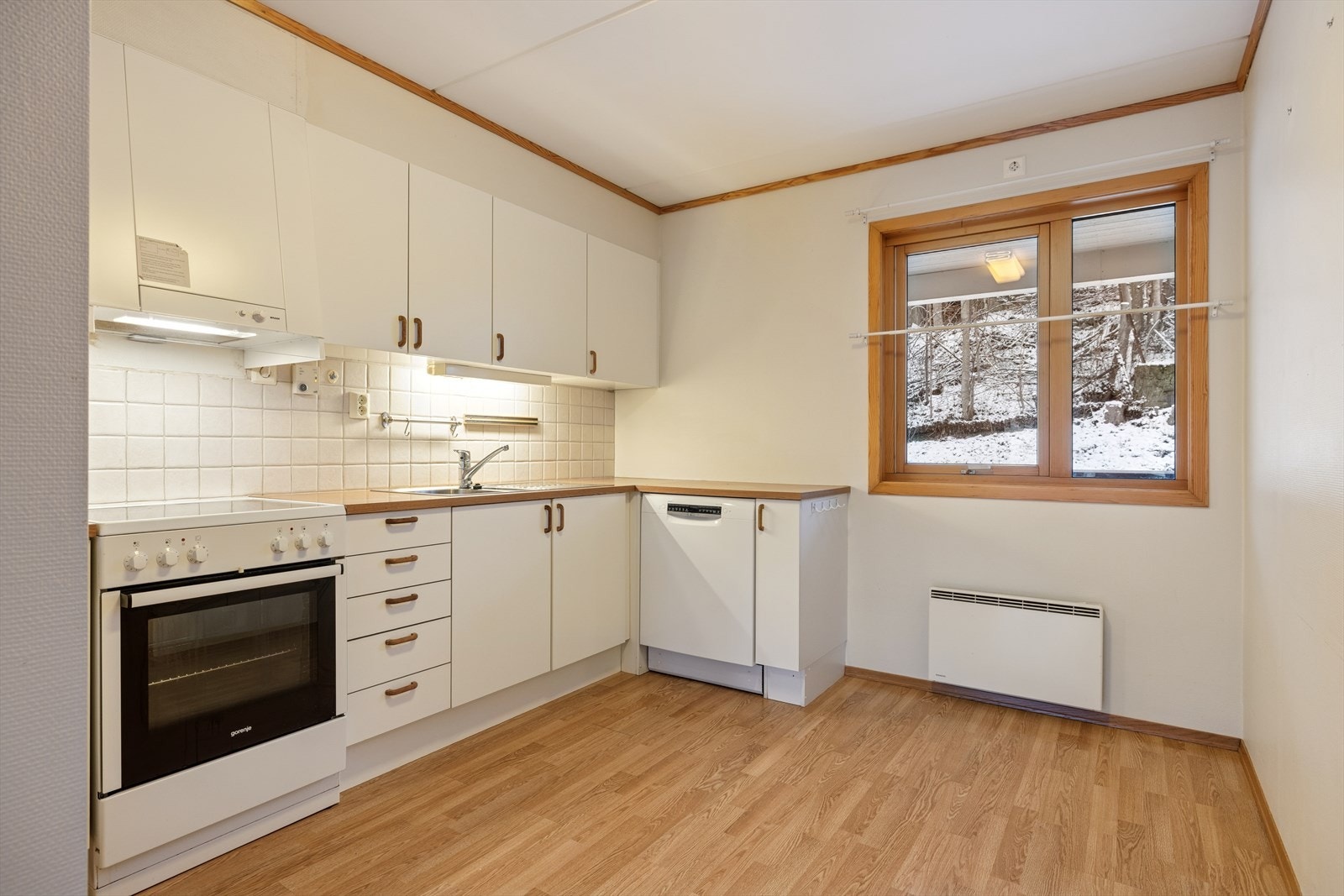 Kjøkkenet er lyst og tidløst. Innredning med hvite slette fronter og benkeplate av typen laminat. Galleribilde