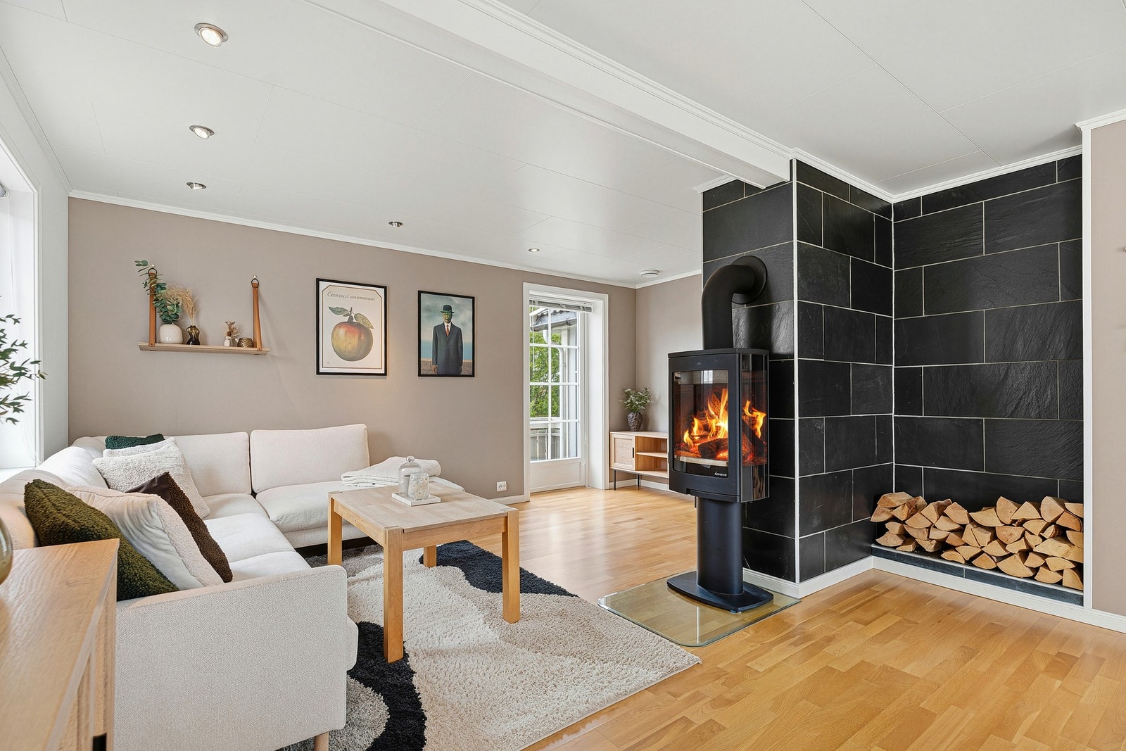 Peisen er et stilig midtpunkt i stuen og flammen kan sees fra alle soner med glass på tre sider Galleribilde