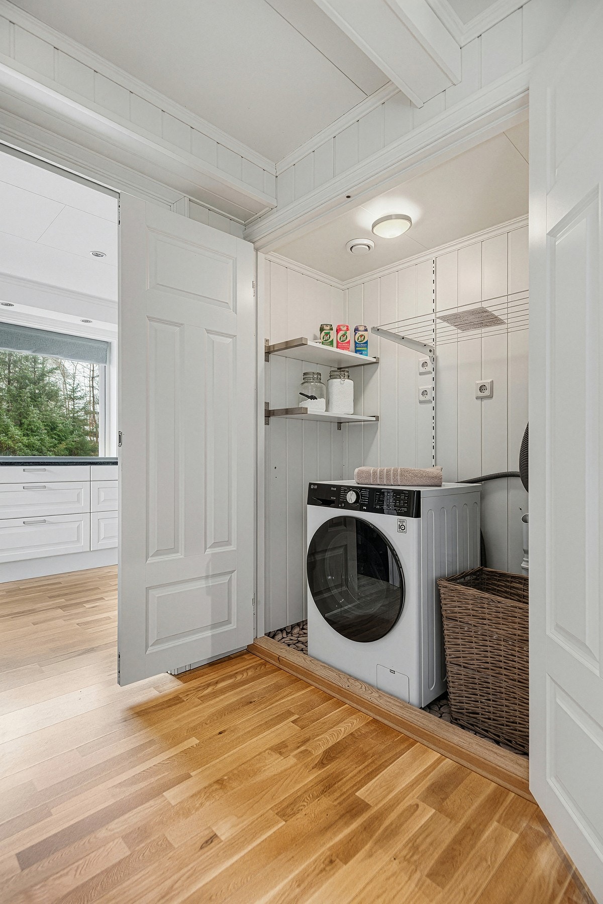 Stilig løsning med oppbevaringsplass, vaskemaskin og motor til sentralstøvsuger Galleribilde