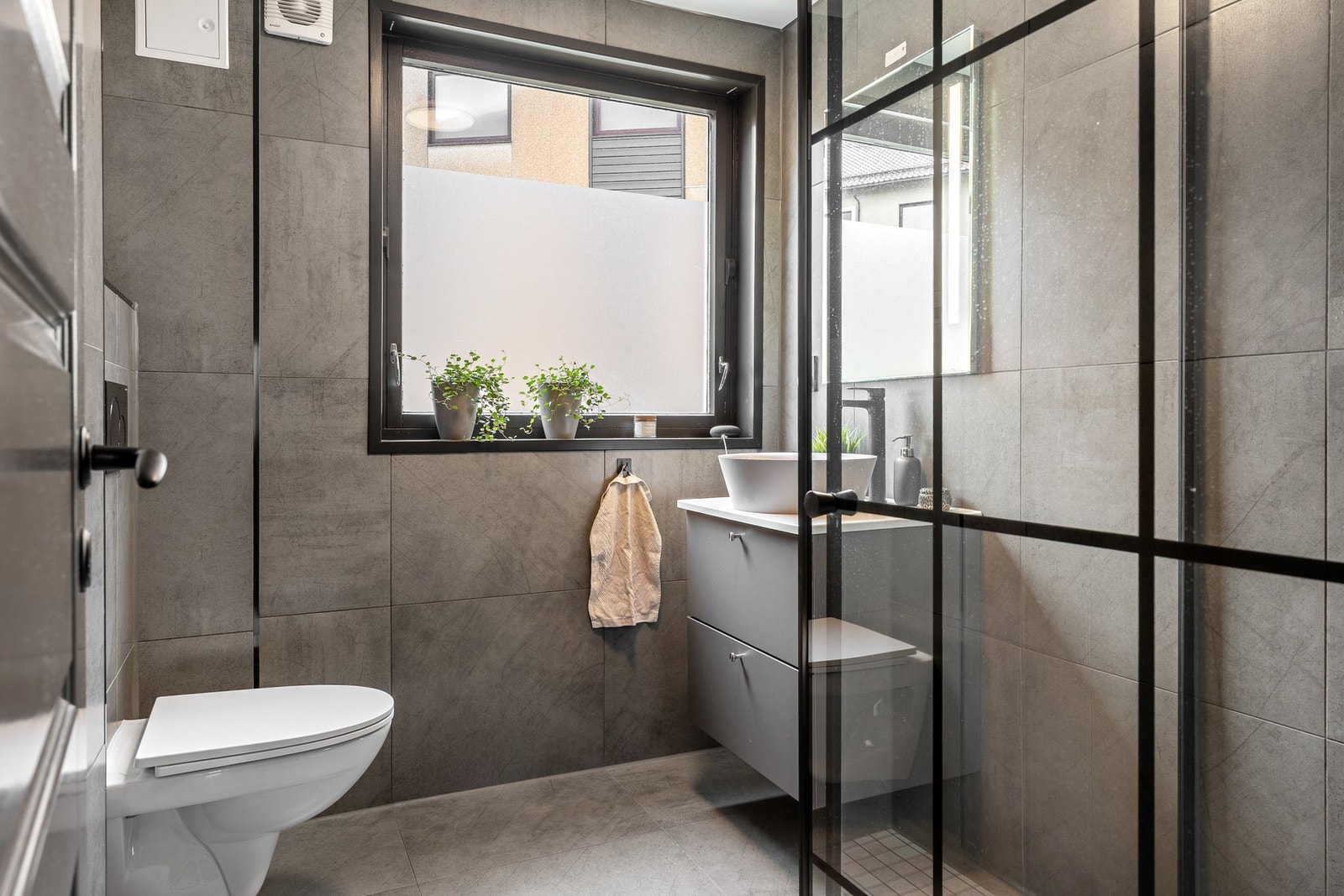 Et lekkert helfliset bad med varmekabler i gulv og slett malt tak. Galleribilde