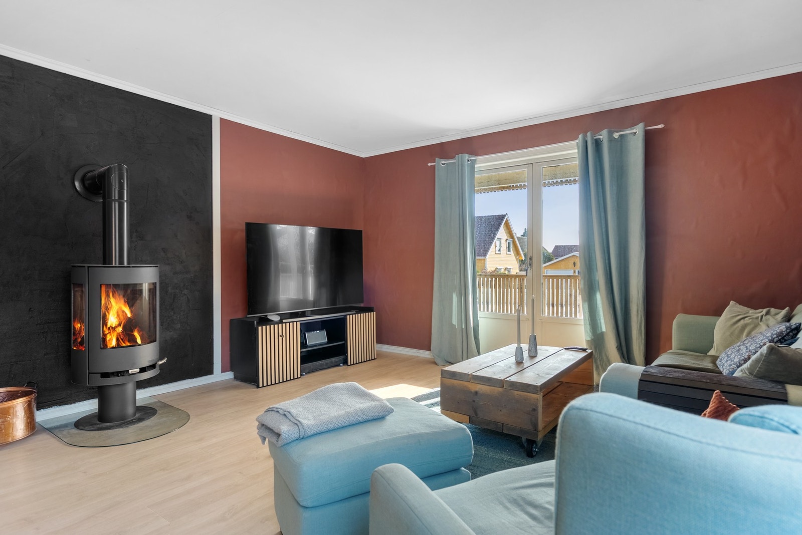 I ene delen av stuen har du vedovn og utgang til en av uteplassene som er tilknyttet denne leiligheten Galleribilde