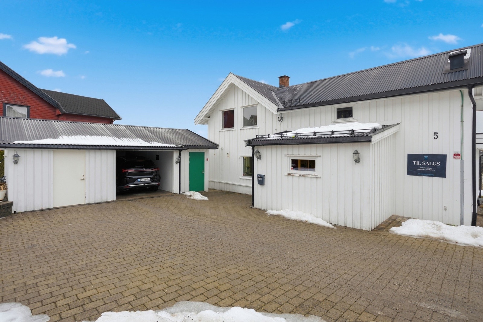 Eiendommen har gode parkeringsmuligheter i frittstående garasje med el-billader samt gårdsplass med belegningsstein Galleribilde