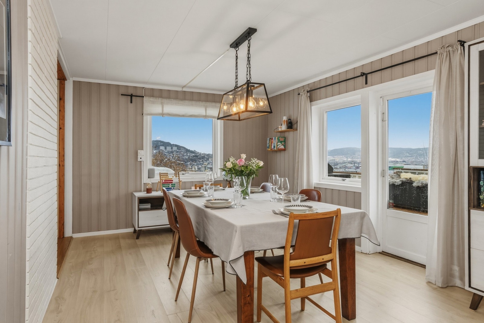 Spisestuen har nydelig utsikt over byen og 1-stavs laminatgulv, panel på vegger samt takplater i himling Galleribilde