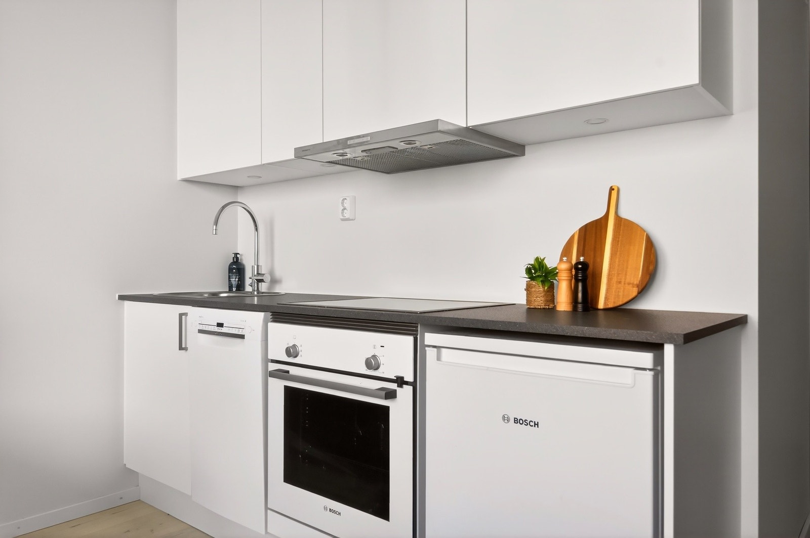 Pent kjøkken som har godt med skap- og benkeplass. Galleribilde