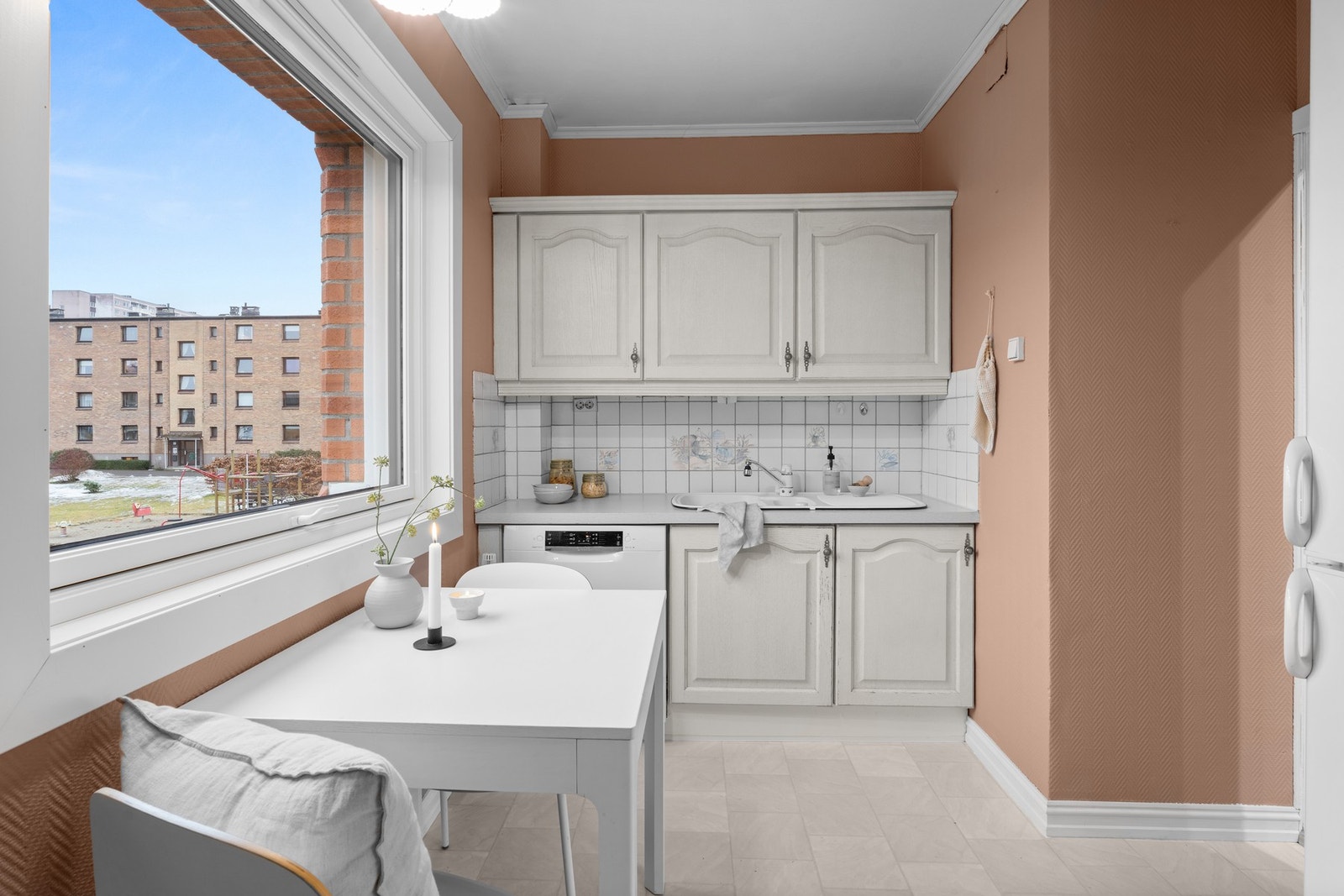 Eldre kjøkkeninnredning med profilerte fronter og laminat
benkeplate. Galleribilde