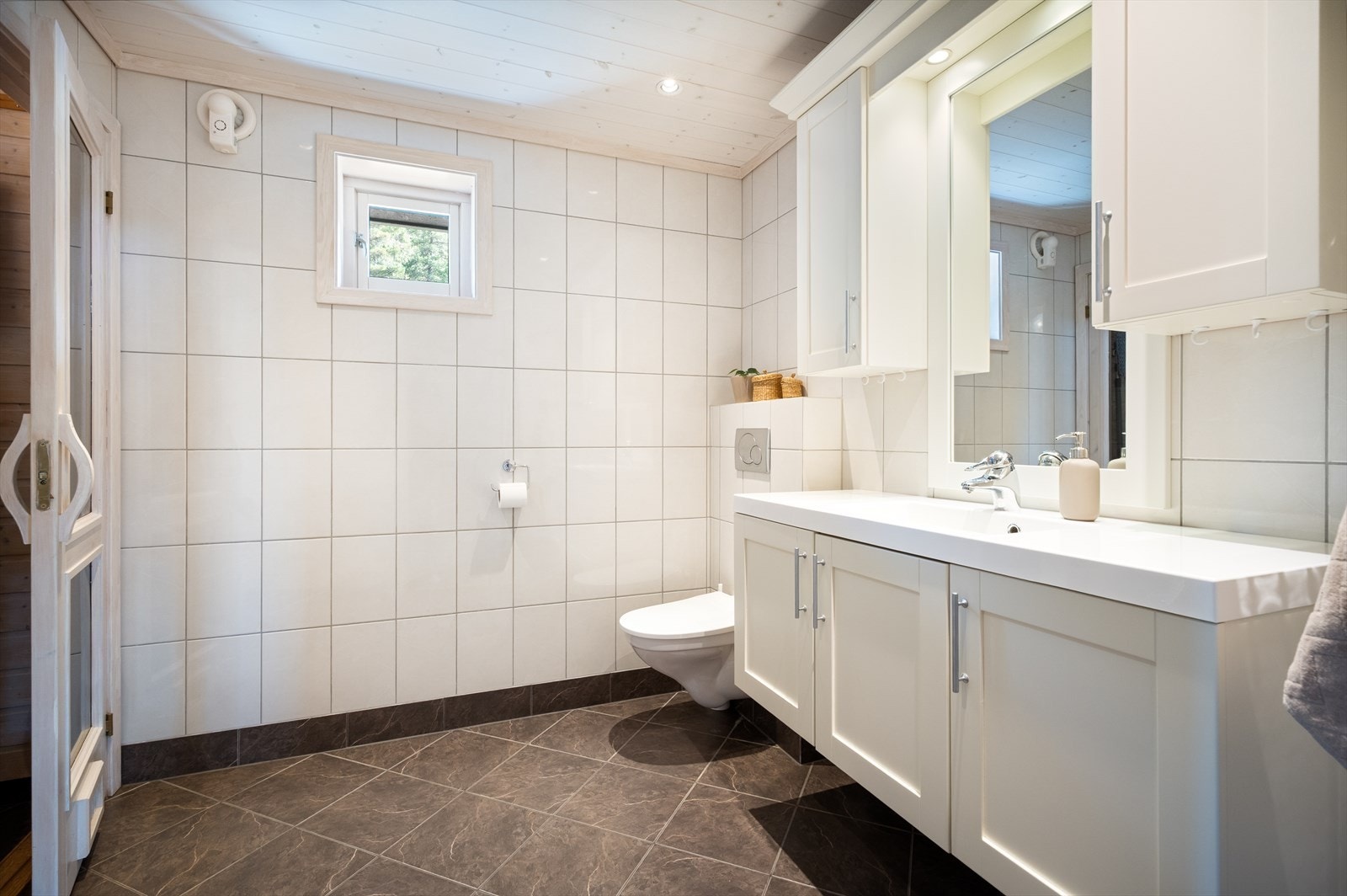 Innredningen er stor og innholdsrik med skap under og over servanten. Galleribilde