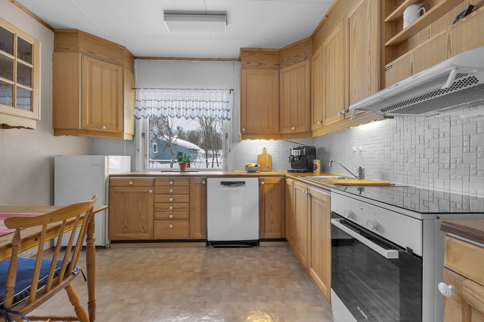 Stort og innholdsrikt kjøkken med vindu mot baksiden av huset. Galleribilde