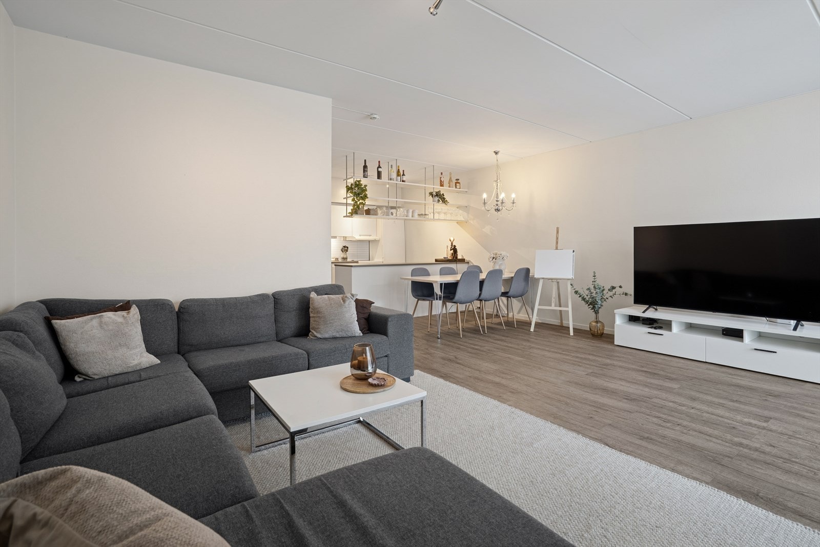 Det er laminat på gulvet og lysmalte plater/betong på veggene. Galleribilde