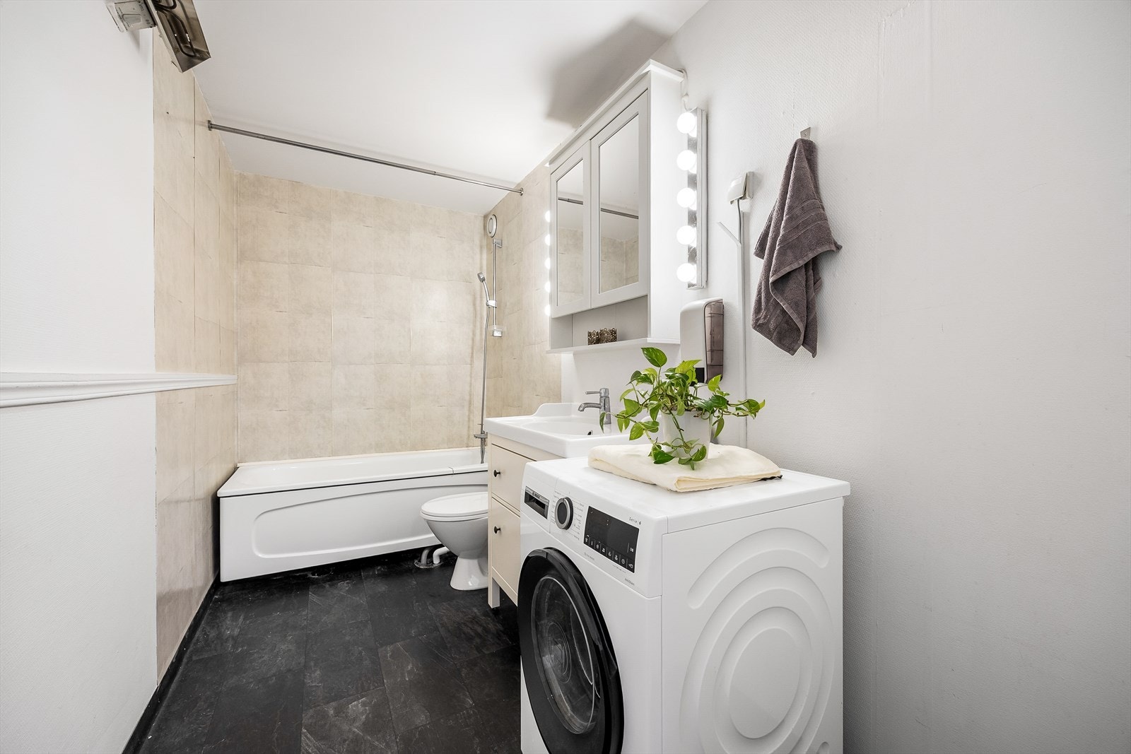 Rommet har badekar med dusjløsning og vinylbelegg på gulvet. Galleribilde