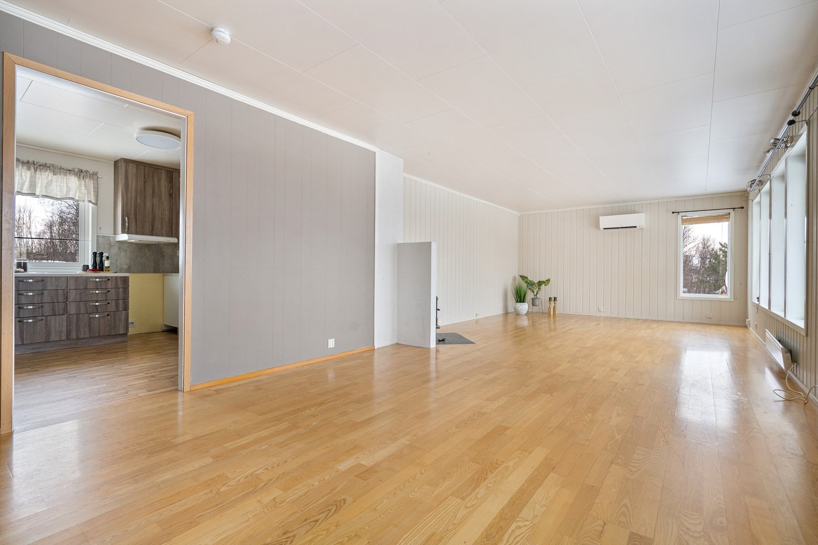 Delvis åpen forbindelse mot kjøkkenet bidrar til en praktisk og sosial planløsning. Galleribilde