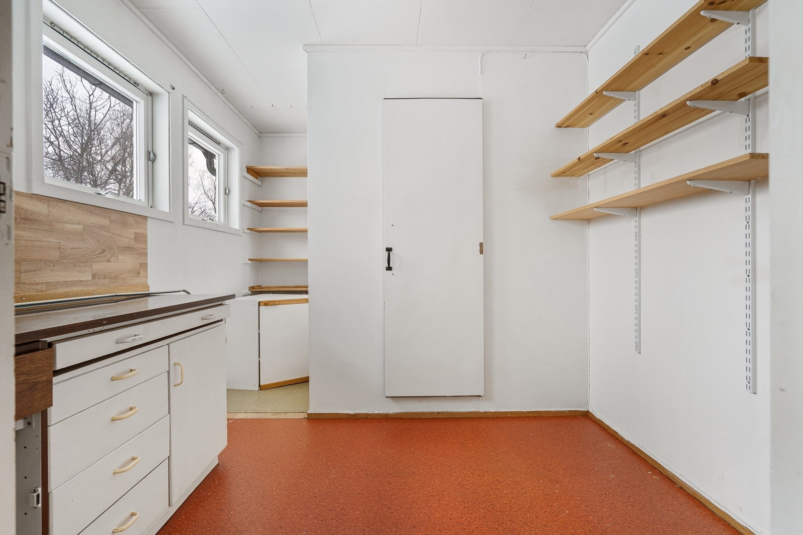 Praktisk rom med gode oppbevaringsmuligheter mellom kjølerom og vaskerom. Galleribilde