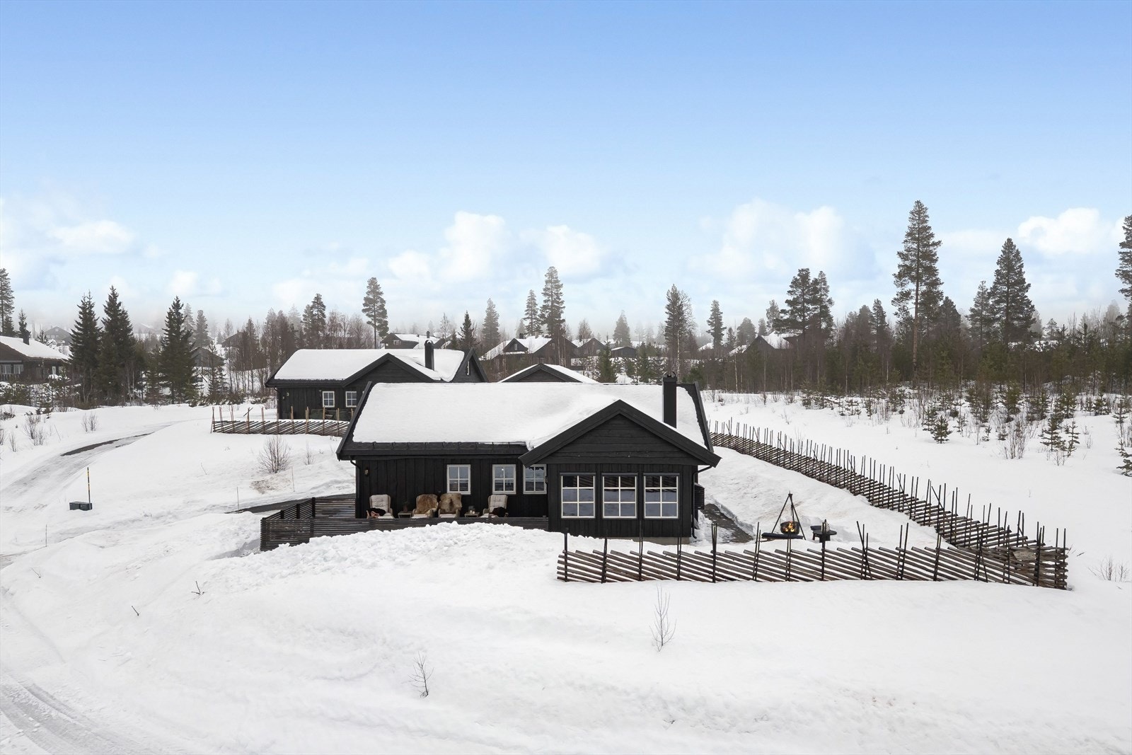 Eiendommen er dels inngjerdet med skigard, som ble satt opp i 2025. Det er også montert screens på stuevinduene og verandadør på utbygget. Galleribilde