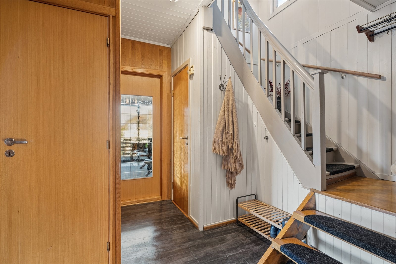 Lys og trivelig entre med flislagt gulv og trappeadkomst til boligens øverste plan. Galleribilde