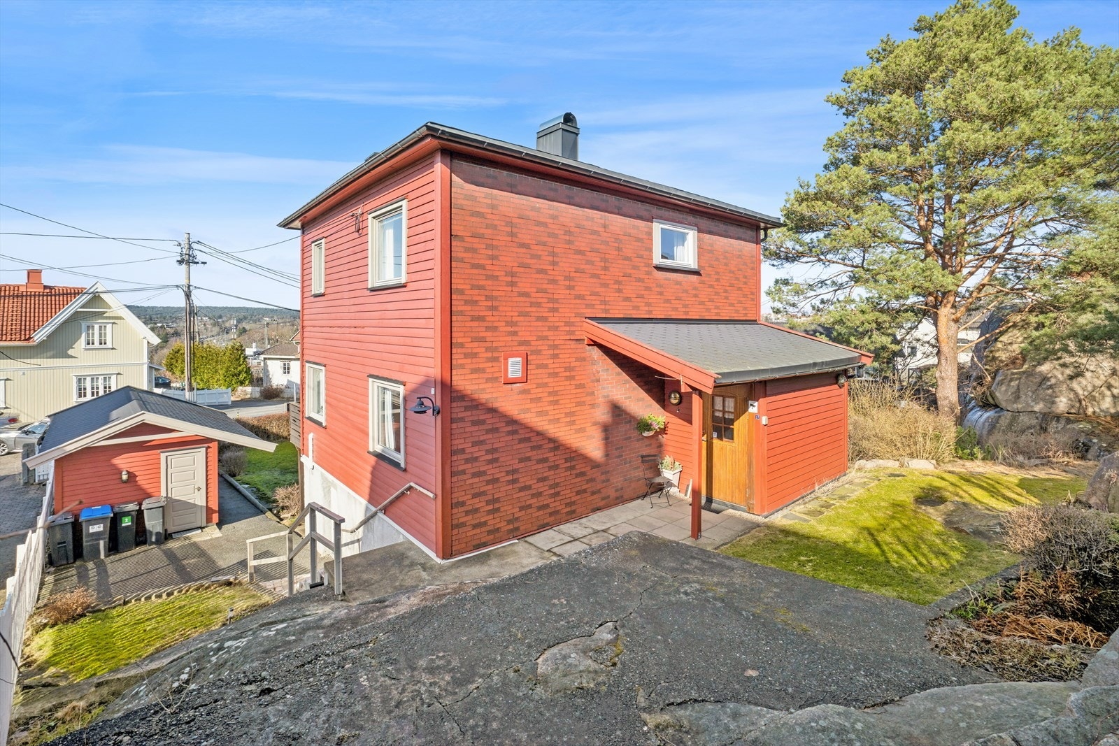 Tomten er skrående og pent opparbeidet med hage, busker og beplantning. Galleribilde