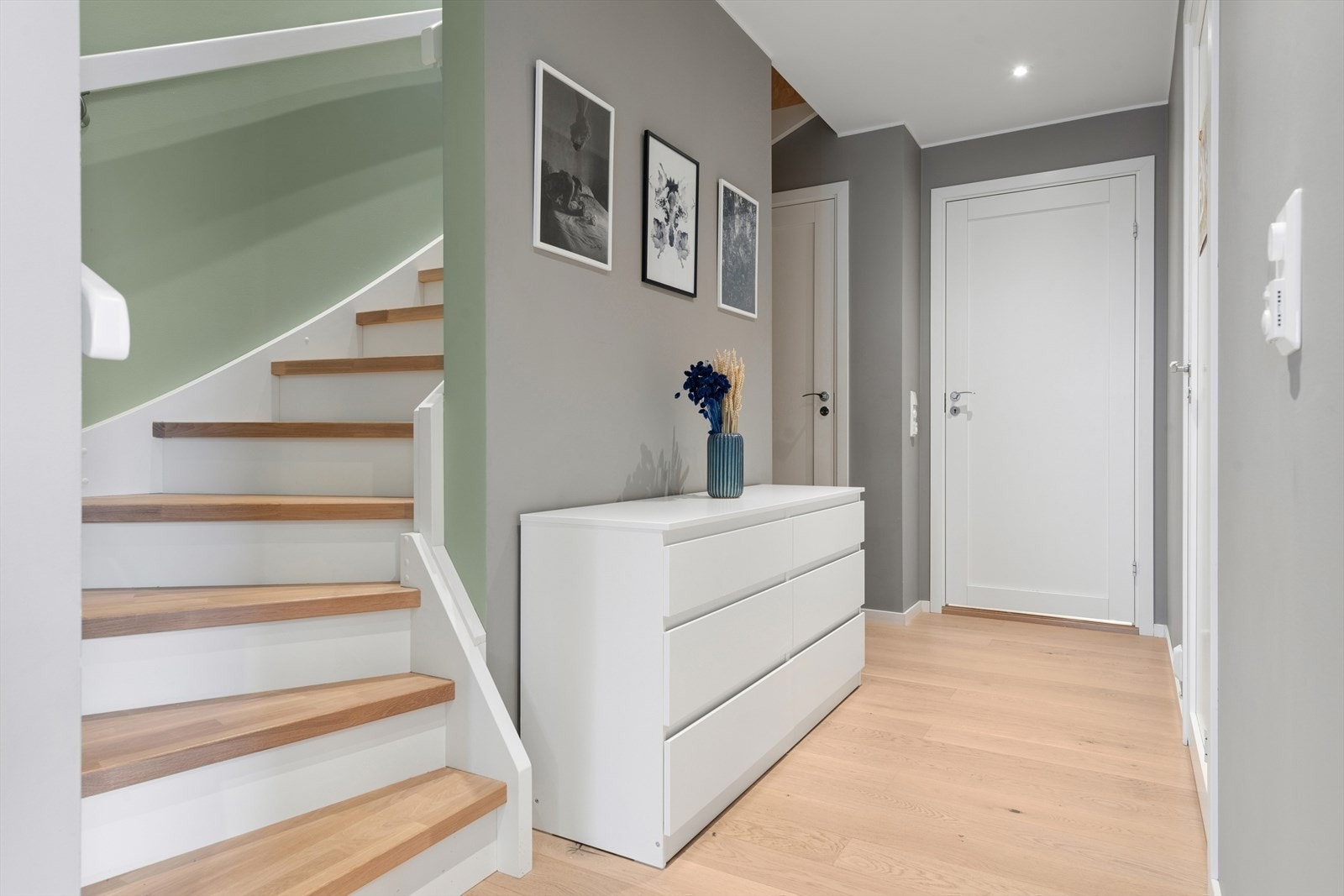 En solid innvendig trapp i treverk med tette opptrinn forbinder etasjene. Galleribilde