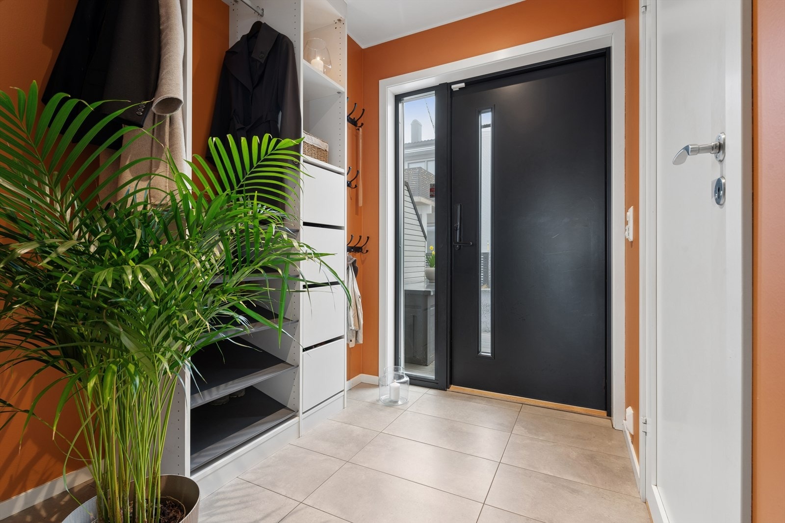 Entréen i 1. etasje har et slitesterkt, flislagt gulv og en ytterdør med kodelås for enkel adkomst. Galleribilde