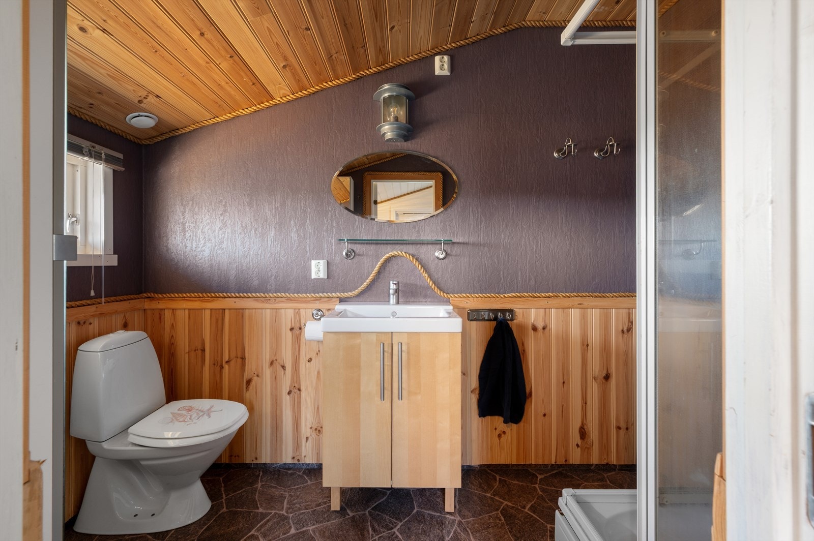 Badet har belegg på gulv og panel samt malte plater på veggene. Galleribilde