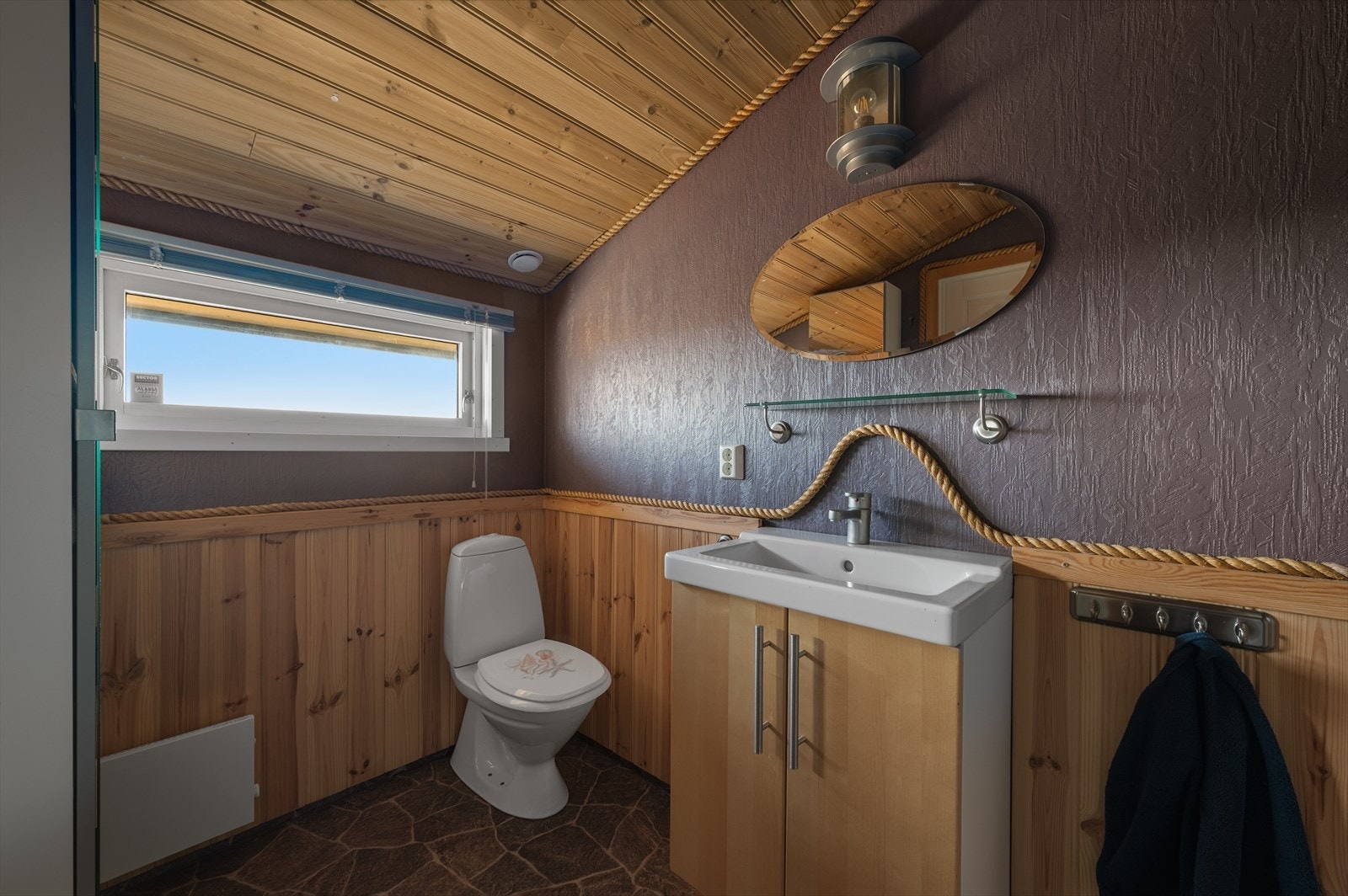 Rommet inneholder dusjkabinett, toalett og vask med innredning. Galleribilde