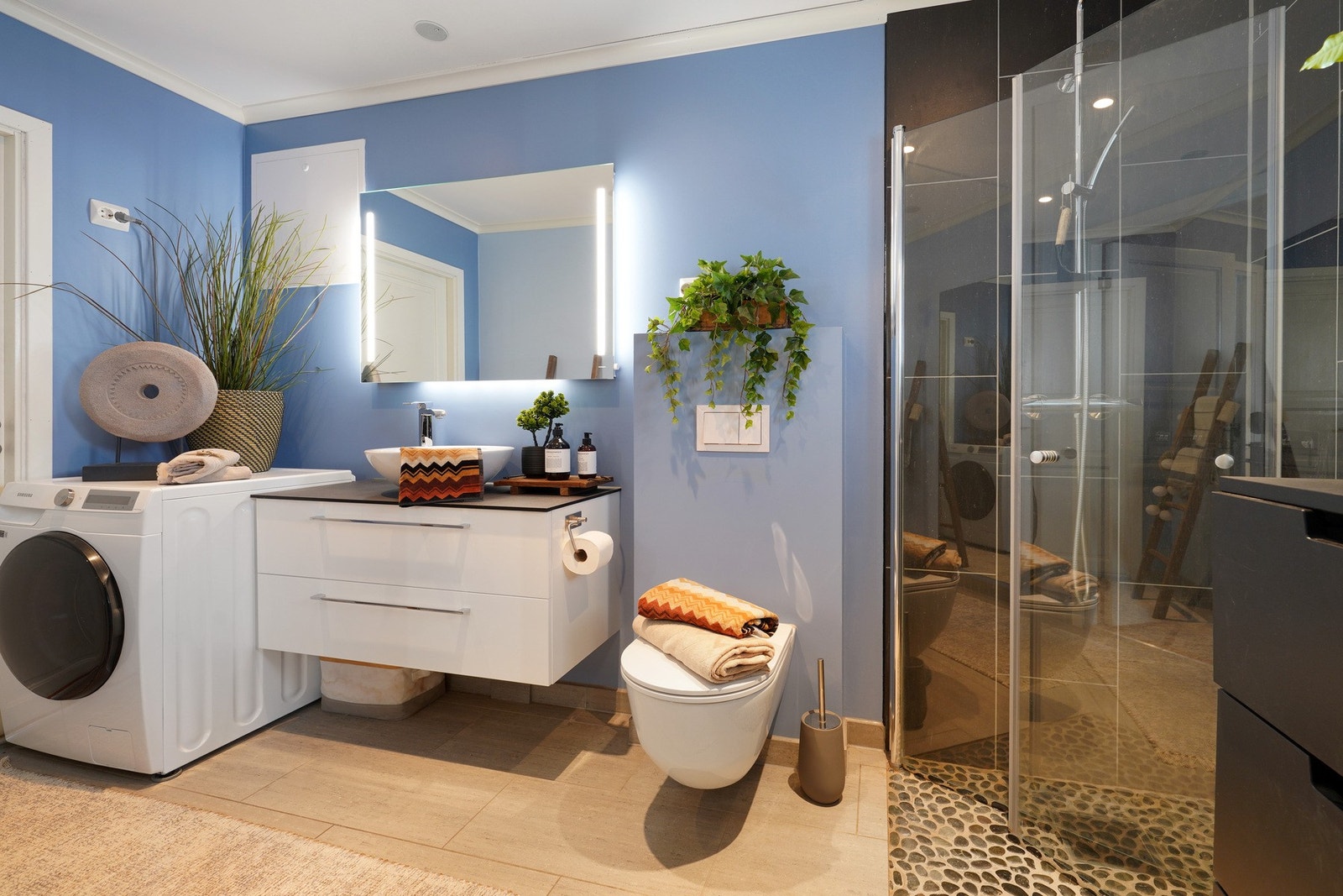 Bad med dusjsone, vask i seksjon, wc og opplegg for vaskemaskin. Galleribilde