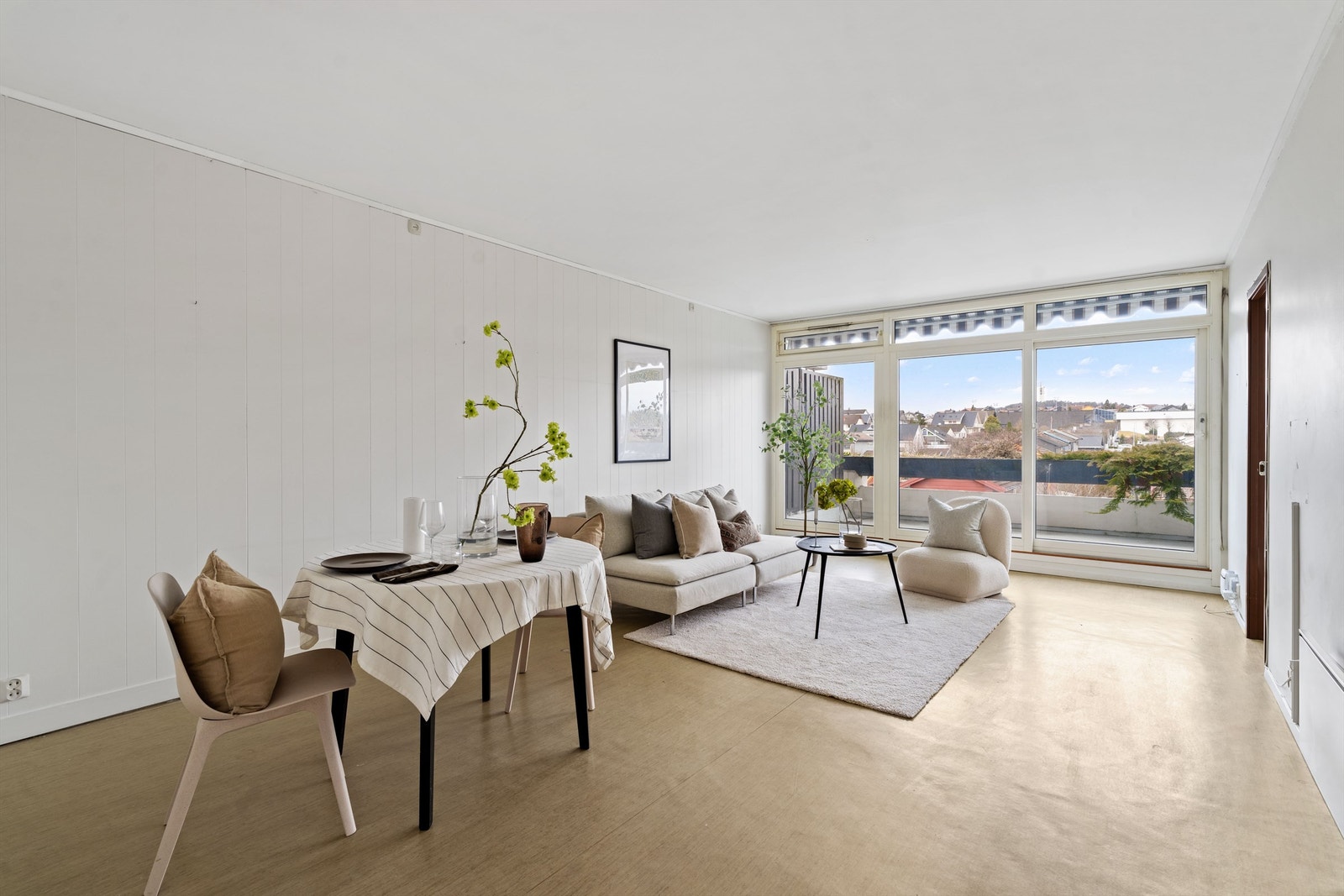 Stuen er lys og romslig, med store vindusflater og god plass til både sofagruppe og spisebord. Galleribilde