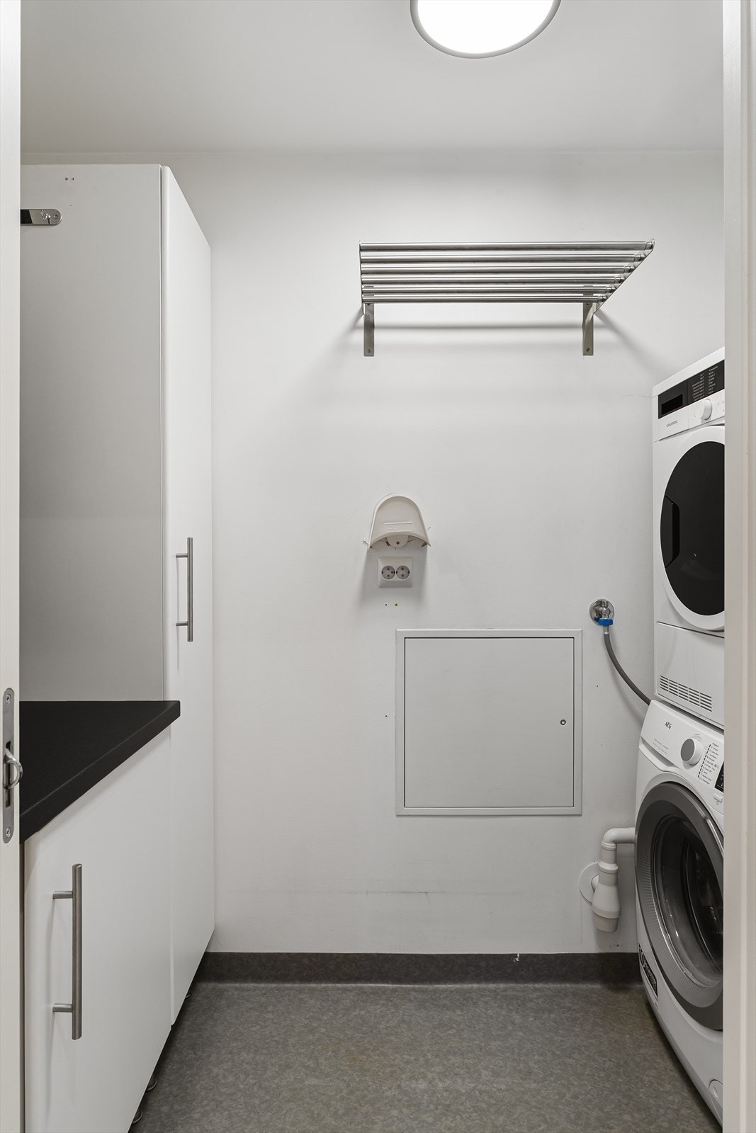 Rommet har opplegg til vaskemaskin/tørketrommel. Praktisk innredning for ekstra oppbevaring. Galleribilde
