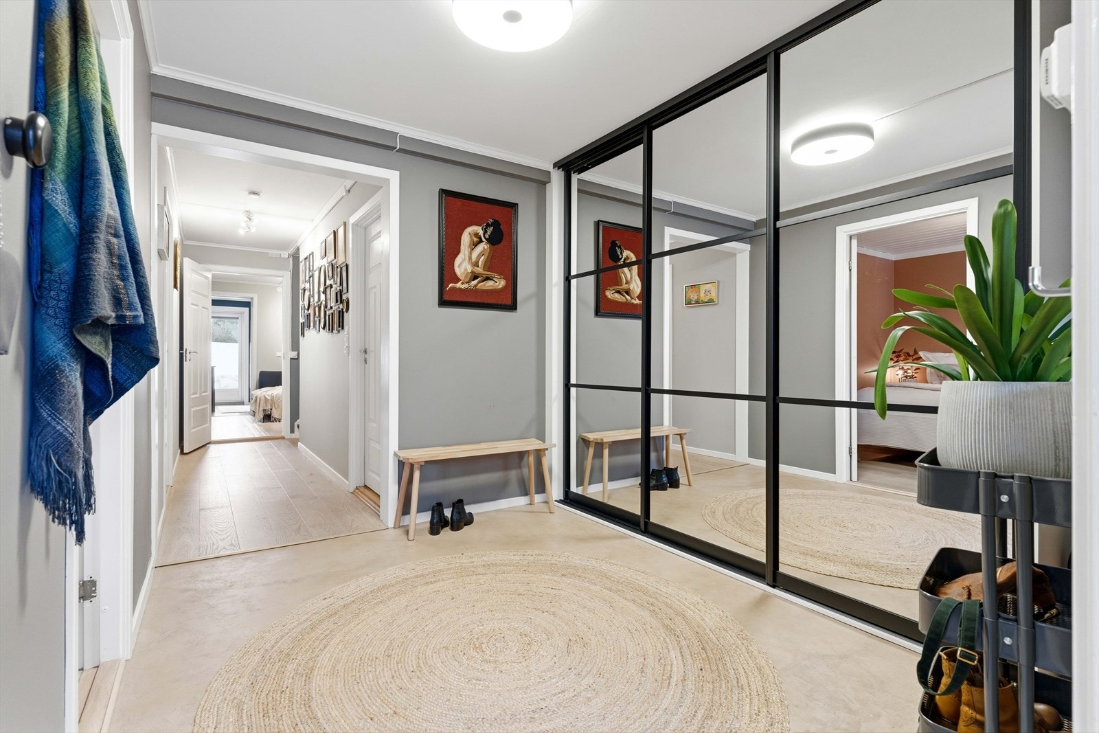 Velkommen inn. Entréen har gulvvarme under et parti med mikrosement og en romslig skyvedørsgarderobe med speilfronter. Galleribilde