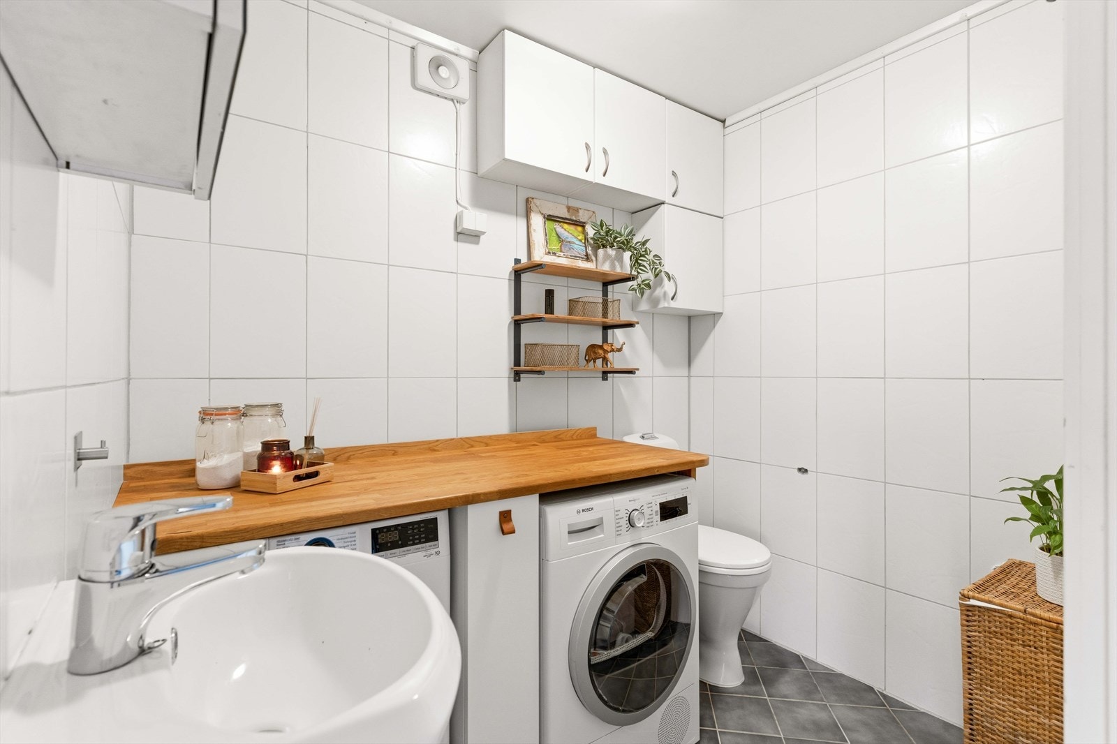 Praktisk vaskerom i andre etasje med flislagt gulv med gulvvarme, toalett og opplegg for vaskemaskin. Galleribilde