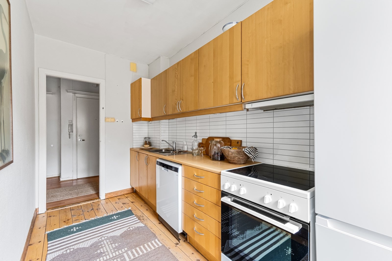 Kjøkkenet er utstyrt med frittstående komfyr, oppvaskmaskin og kjøl/frys. Avtrekksvifte over koketopp med kullfilter. Det er montert elektrisk avtrekk på vegg. Galleribilde